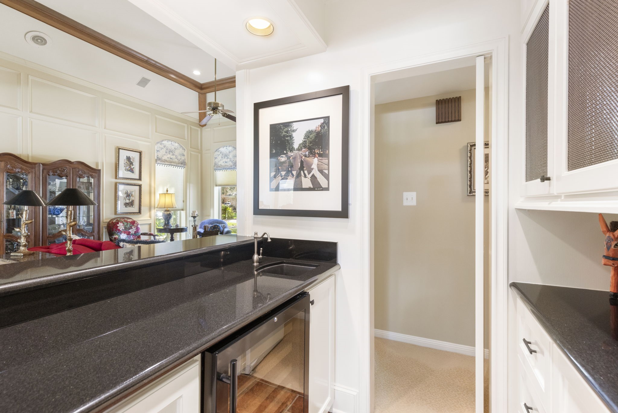 Dark counters, a prep sink, and ample cabinetry make this dedicated beverage station as practical as it is inviting.