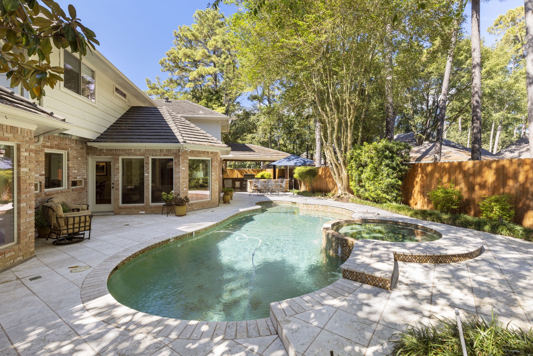 A raised spa and welcoming pool extend the home's entertaining possibilities into a beautifully enclosed outdoor setting.