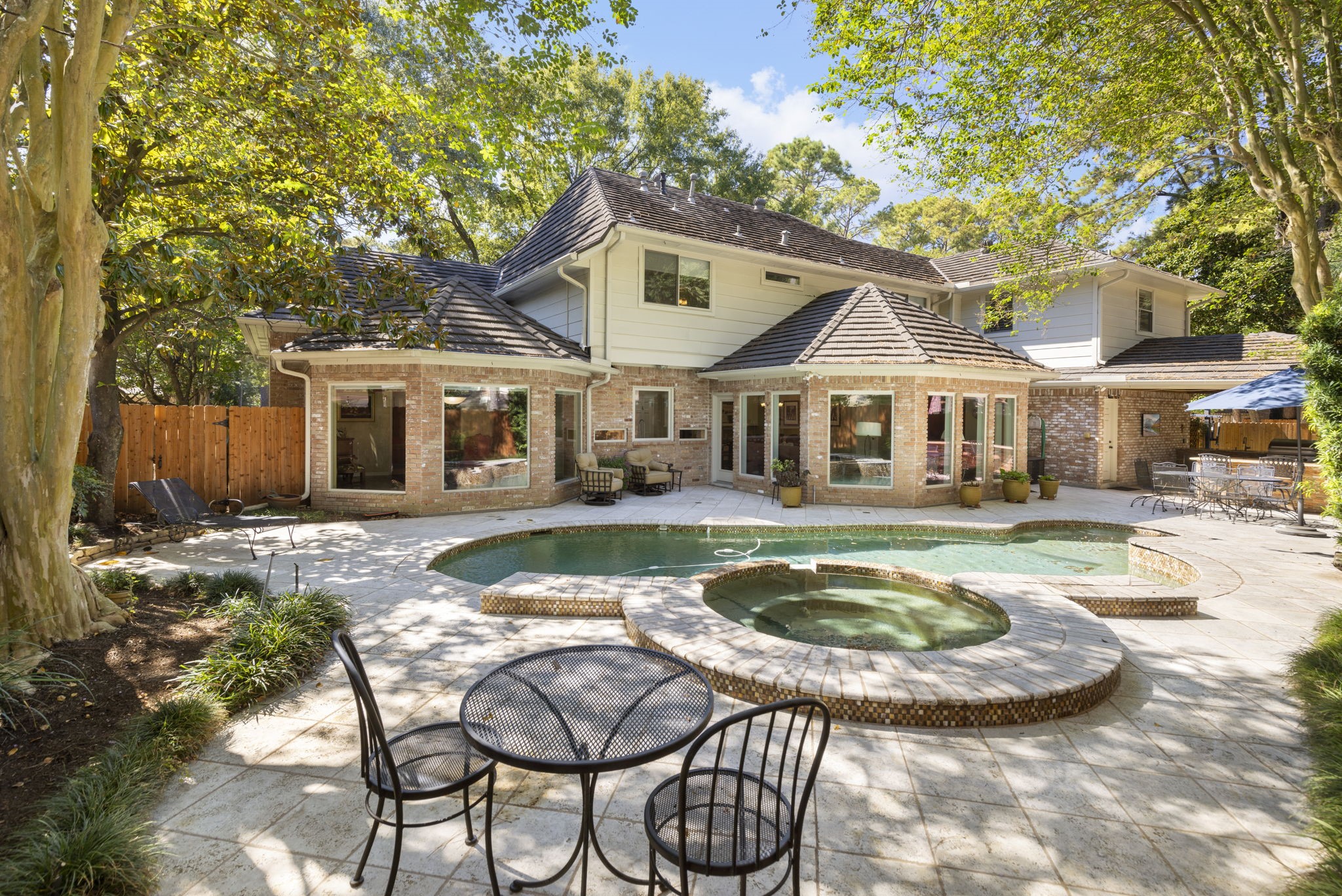 A sparkling pool and raised spa anchor a secluded backyard designed for leisurely afternoons and memorable gatherings.