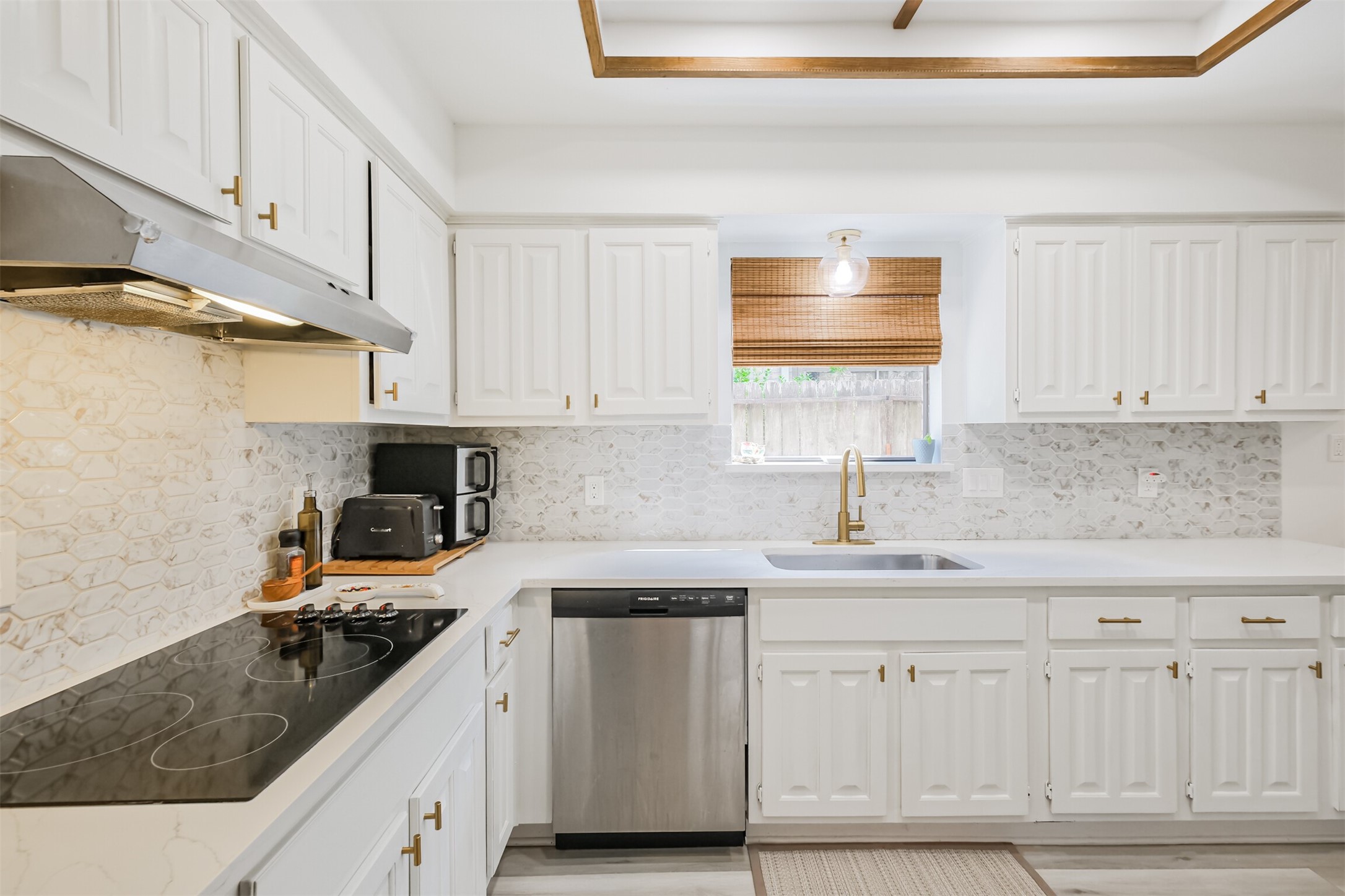 There is a electric cooktop with vent hood and SS dishwasher.