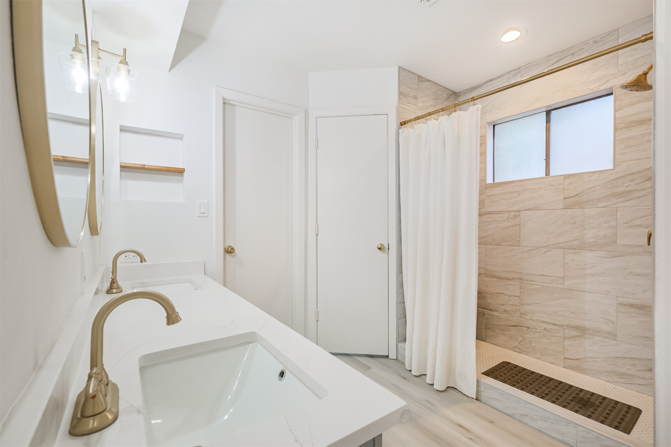 The primary bathroom has double sinks, quartz counters and a standing shower with tile surround.