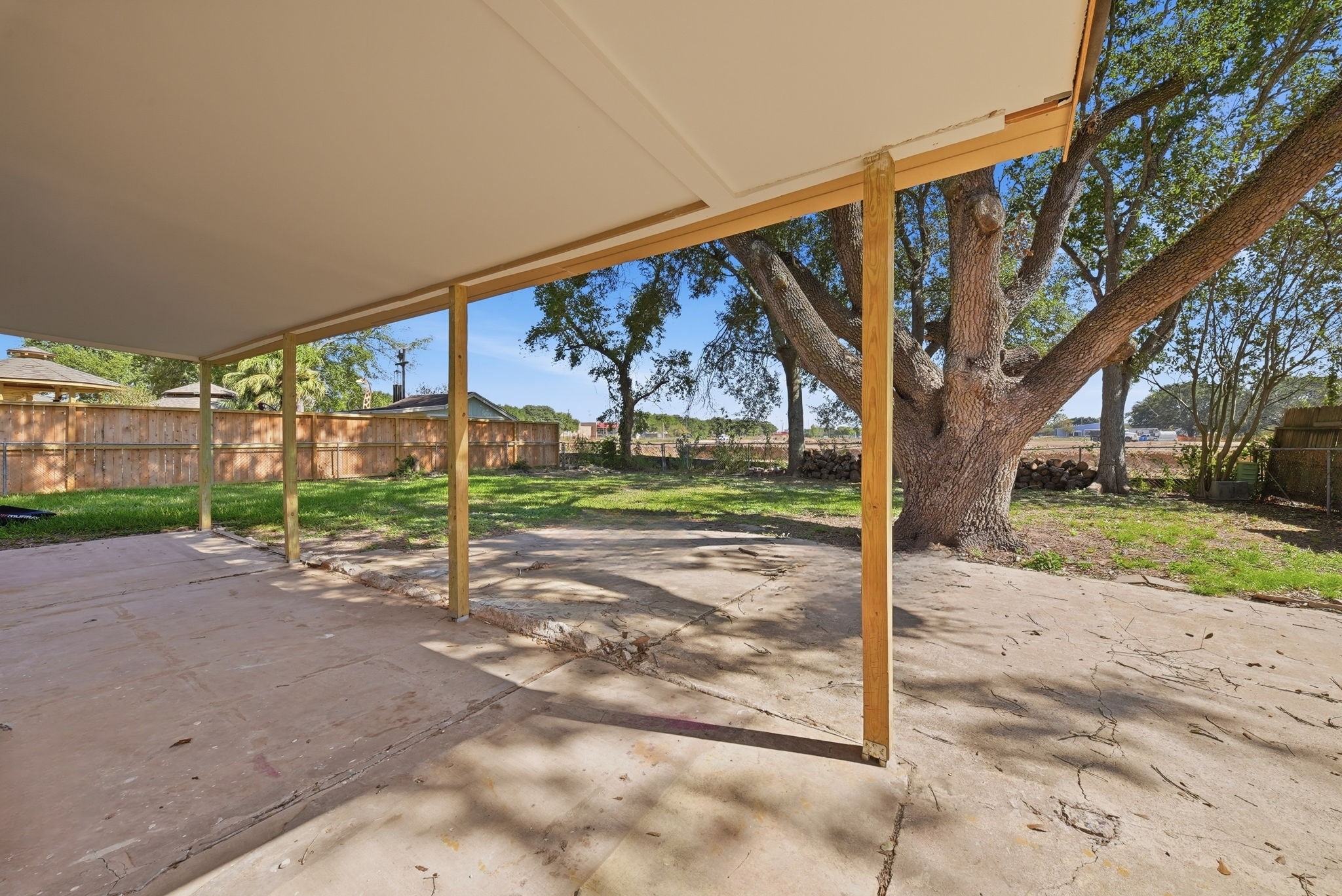 Morning coffee on the covered patio, shaded by a large oak, with open views past the back fence.