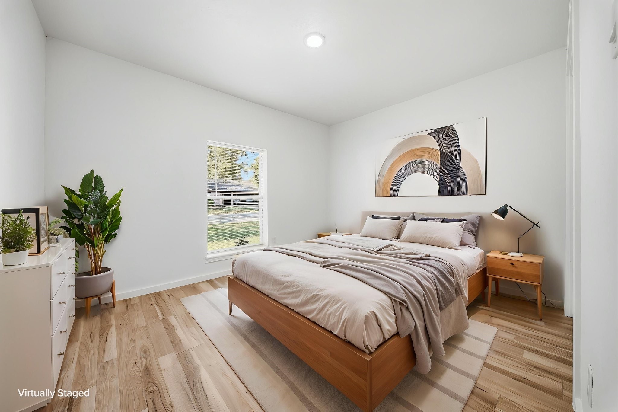Virtually staged. Secondary bedroom with a front-yard window and space for a queen bed and dresser.