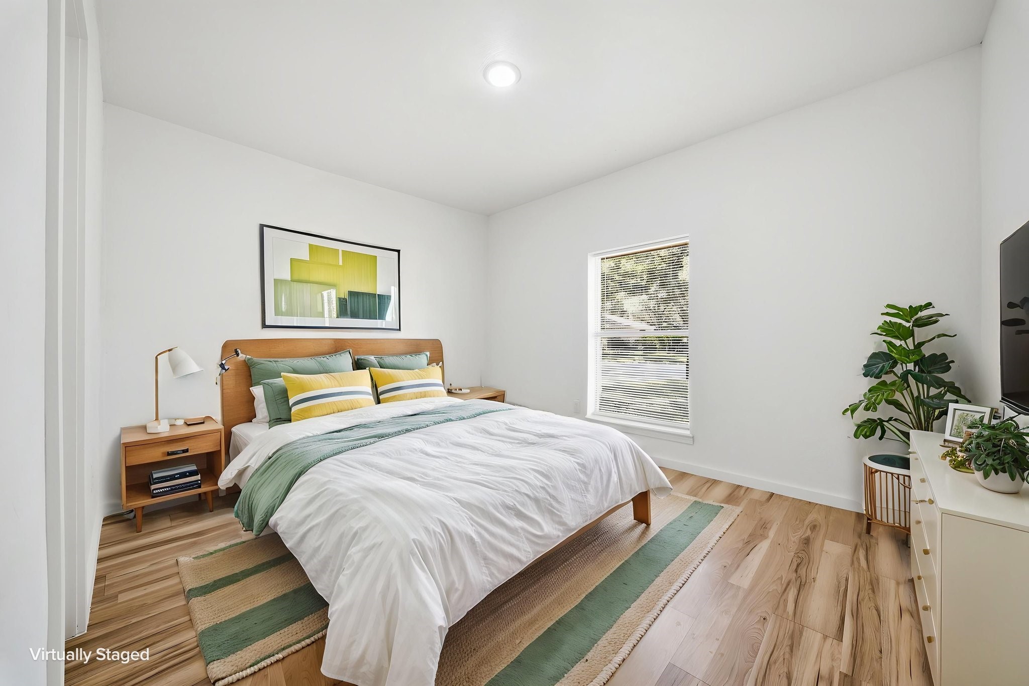 Virtually staged. Third bedroom set up with a bed, nightstands and a dresser, with a window to the trees.