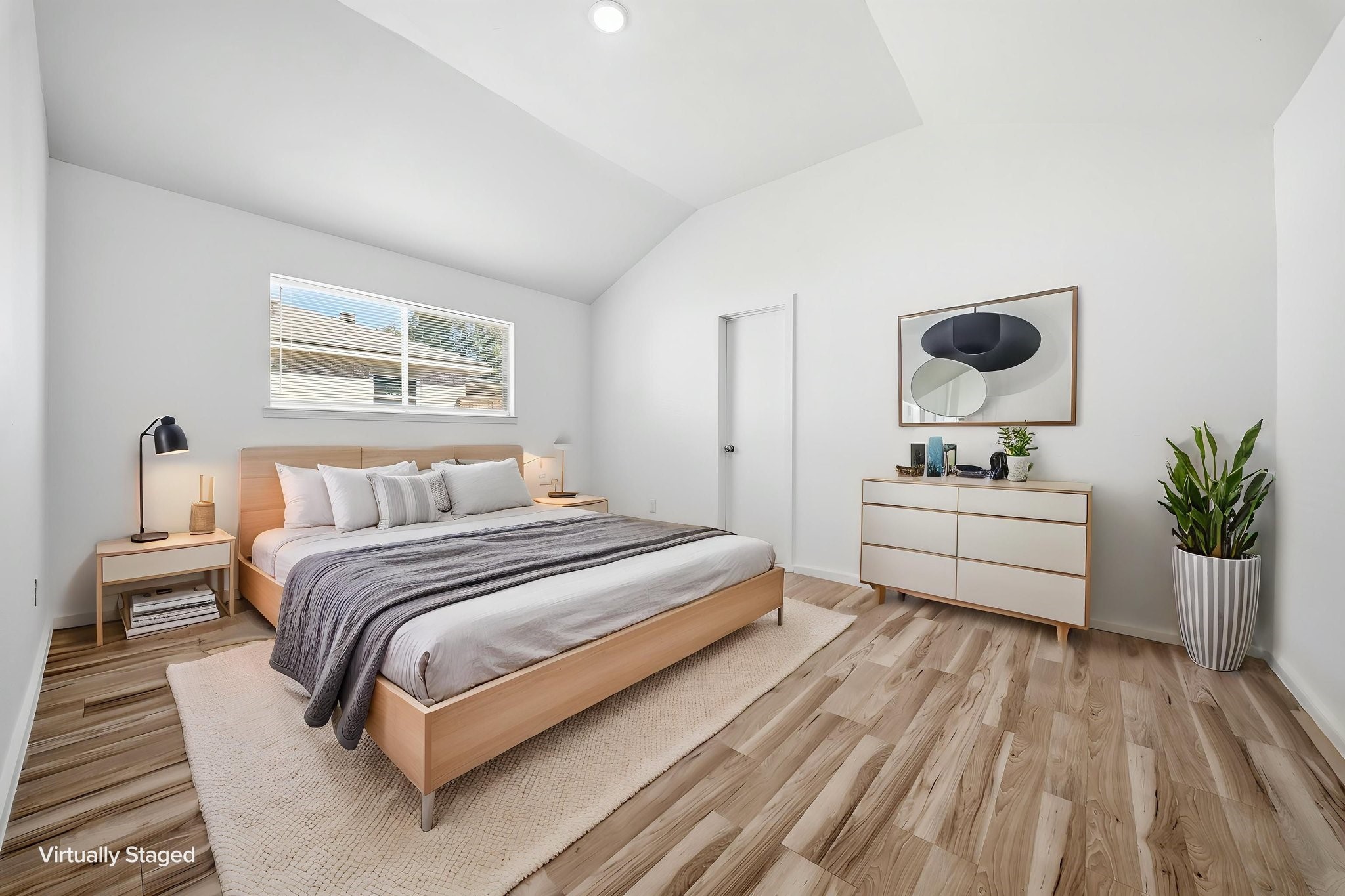Virtually staged. Primary bedroom with a vaulted ceiling, room for a king bed and a private bath through the door.