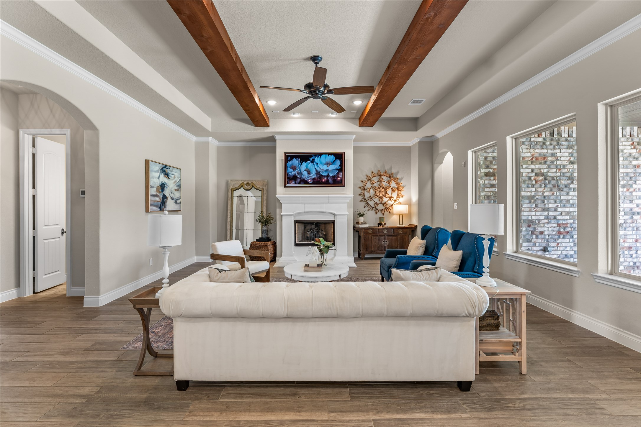 Statement living room featuring soaring ceilings, wood beam accents, and abundant natural light