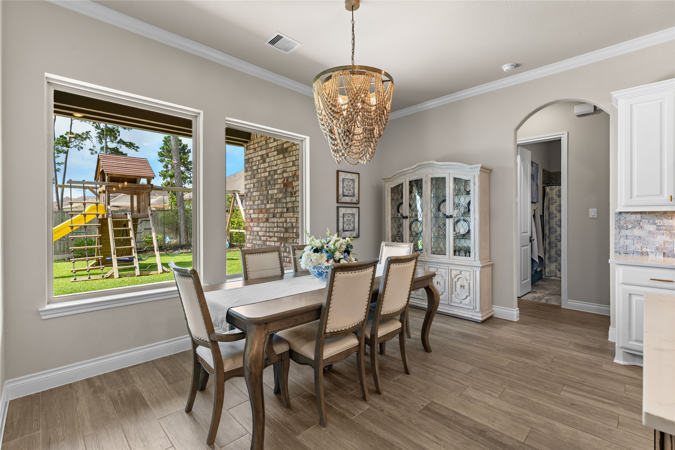 Dining area framed by large windows overlooking the backyard