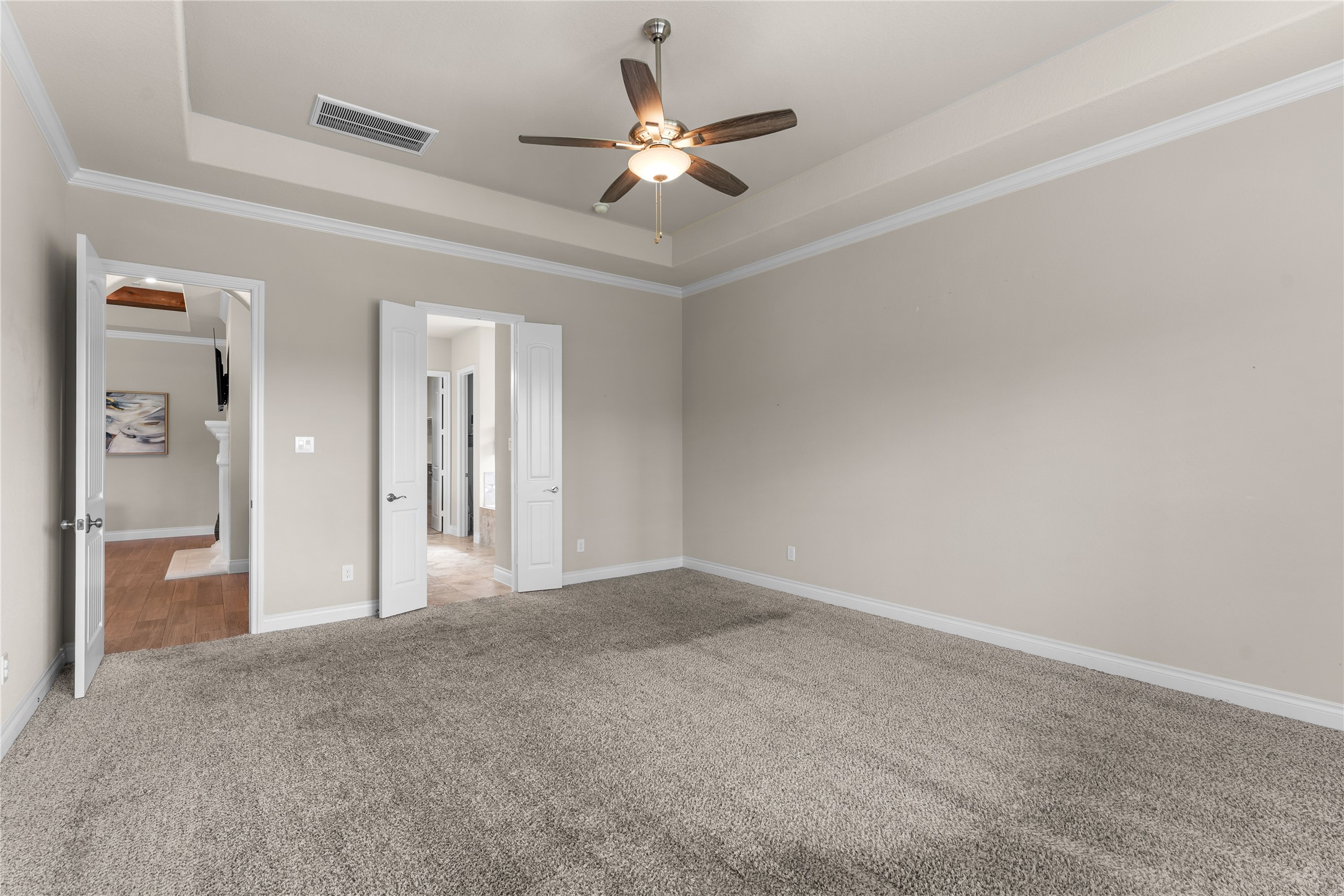 Oversized primary bedroom with tray ceilings and room to unwind.