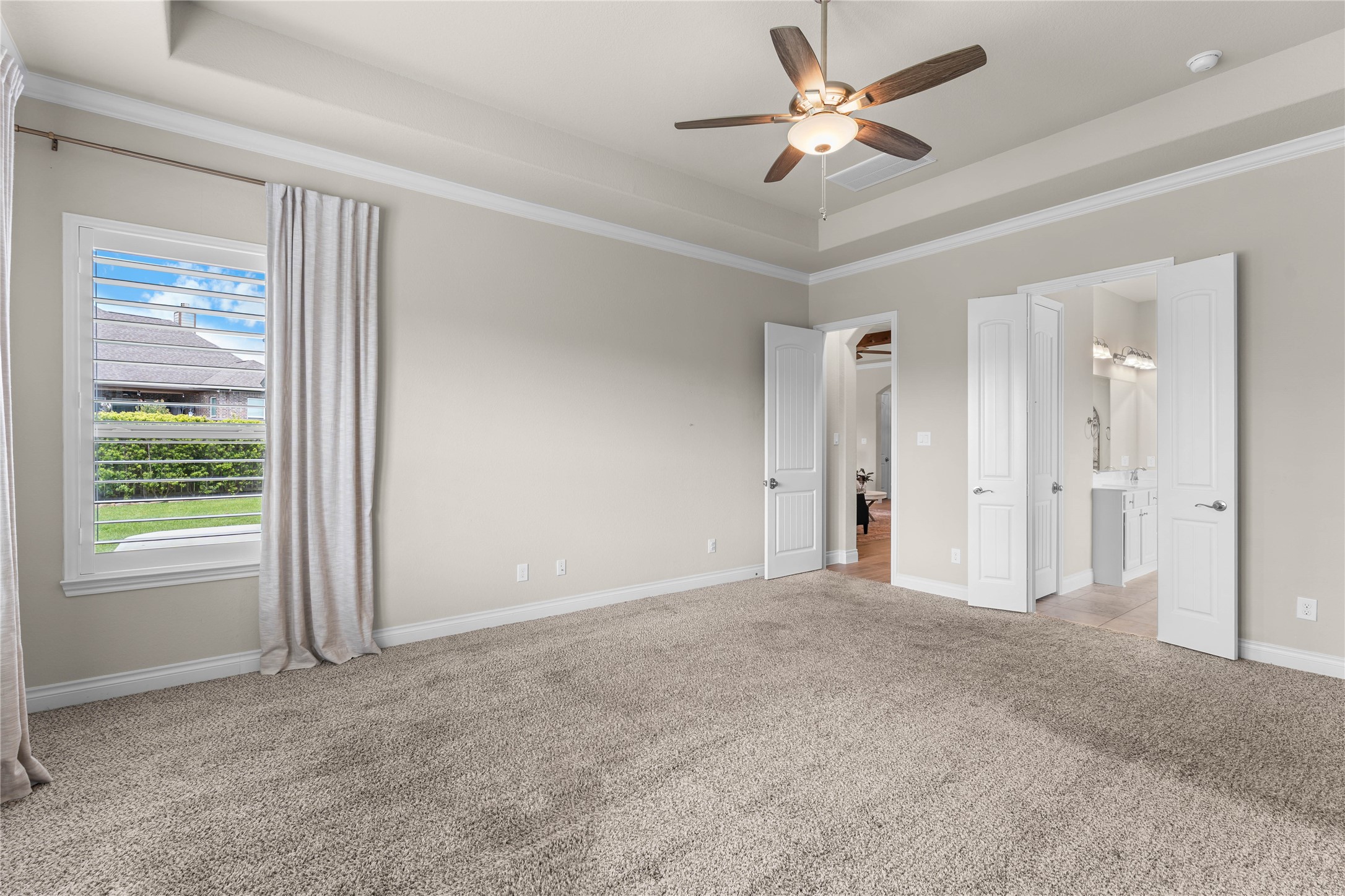 Spacious primary suite filled with natural light and calming neutral tones.