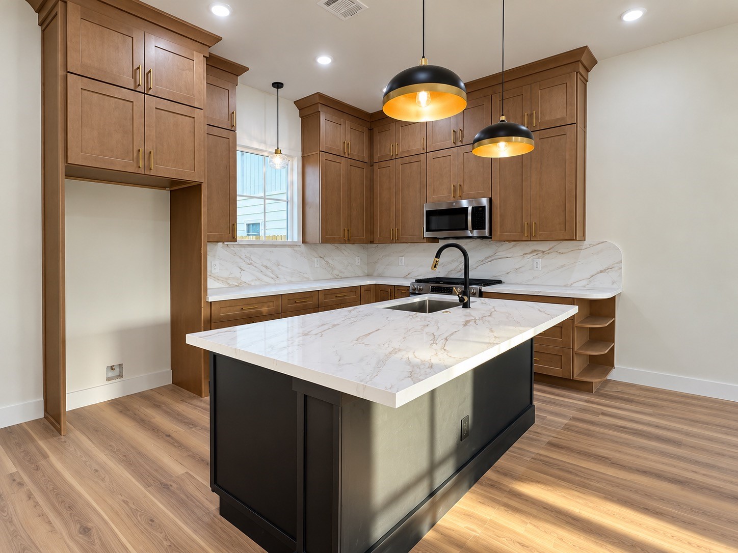 Elegant kitchen featuring rich wood cabinetry, natural lighting complemented by modern lighting and stainless steel appliances.This photo has been virtually rendered based on the plans for this home.