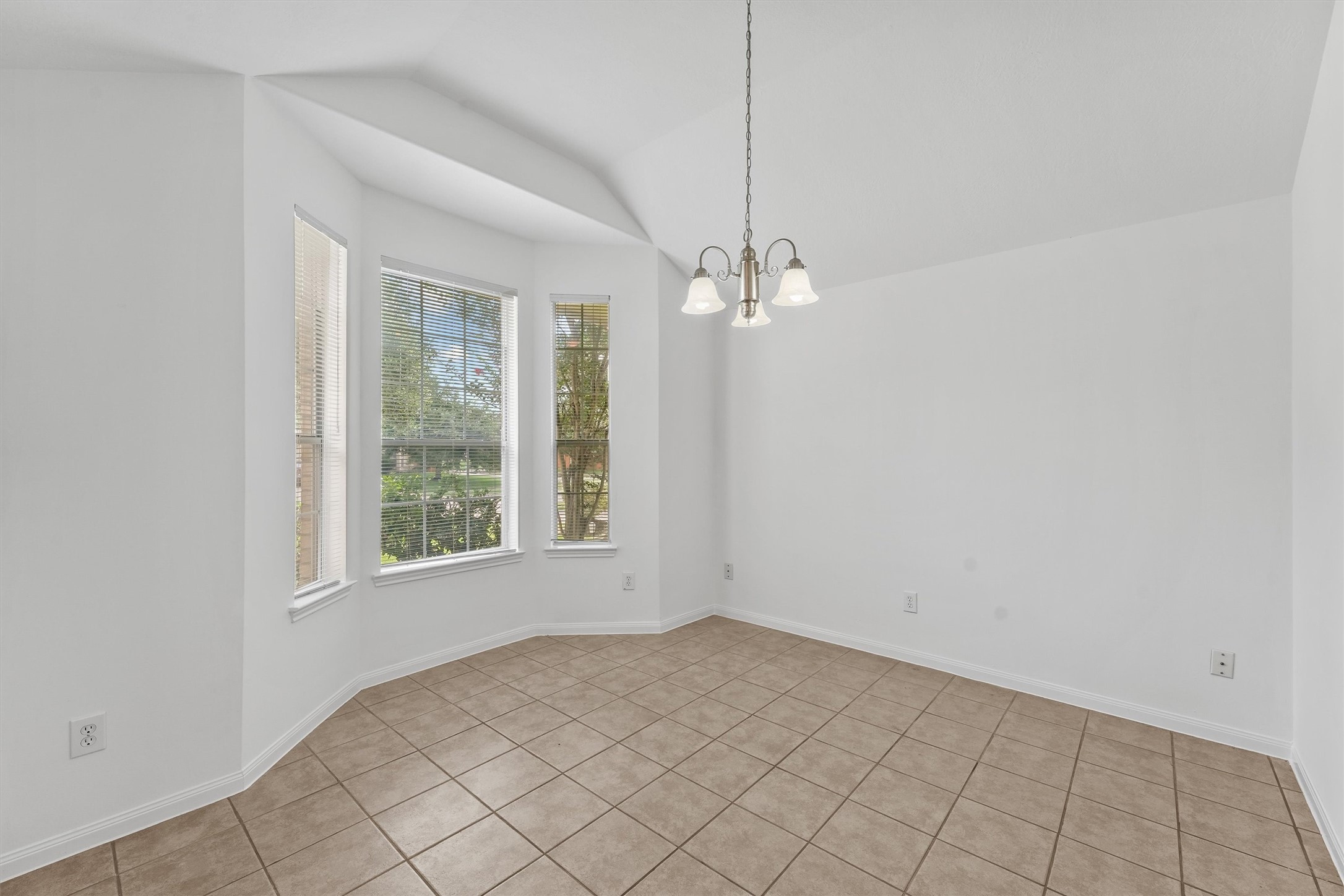 The dining room has boasts a bay window which lets the outside in.