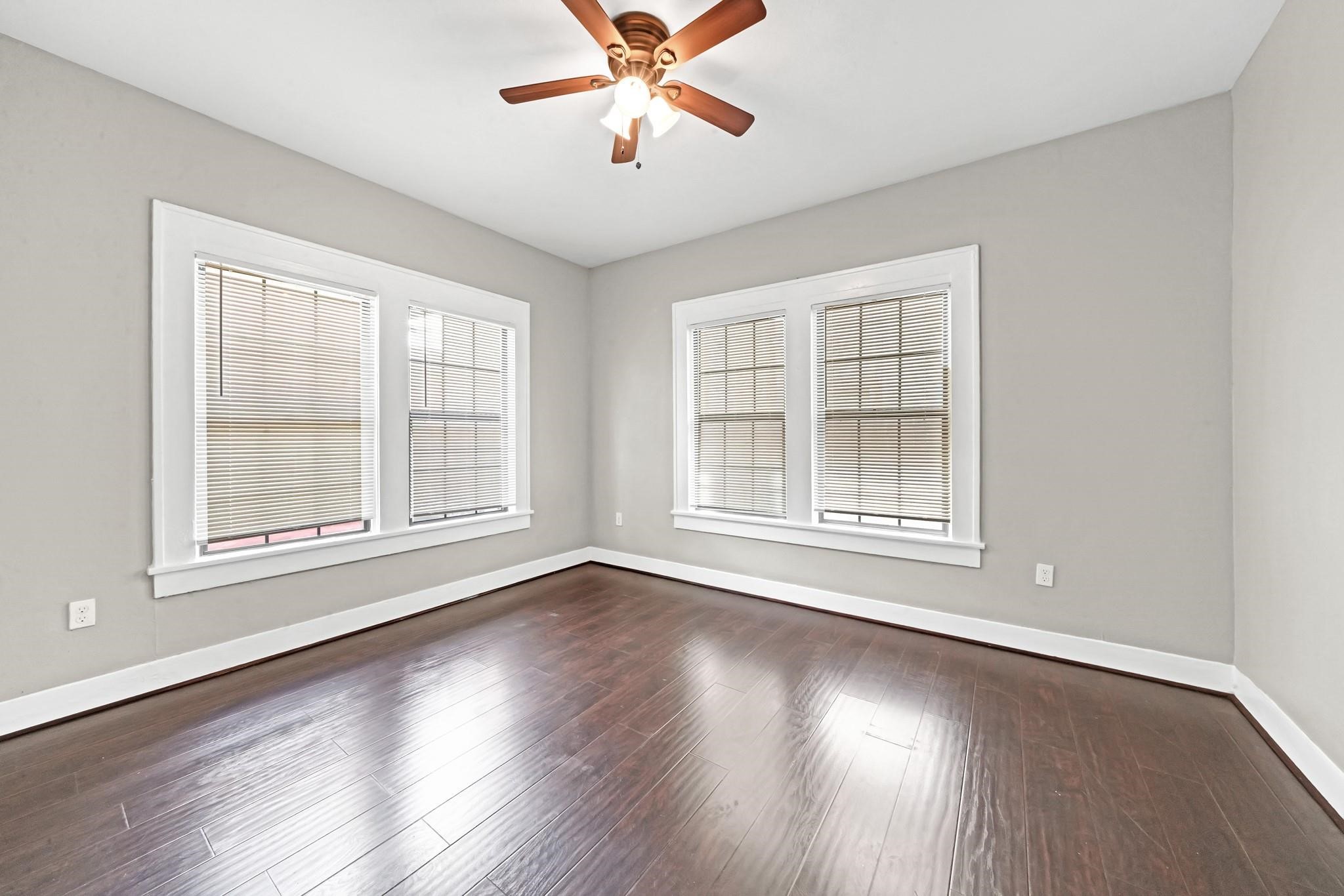 Spacious bedroom featuring hardwood flooring and plenty of natural light.