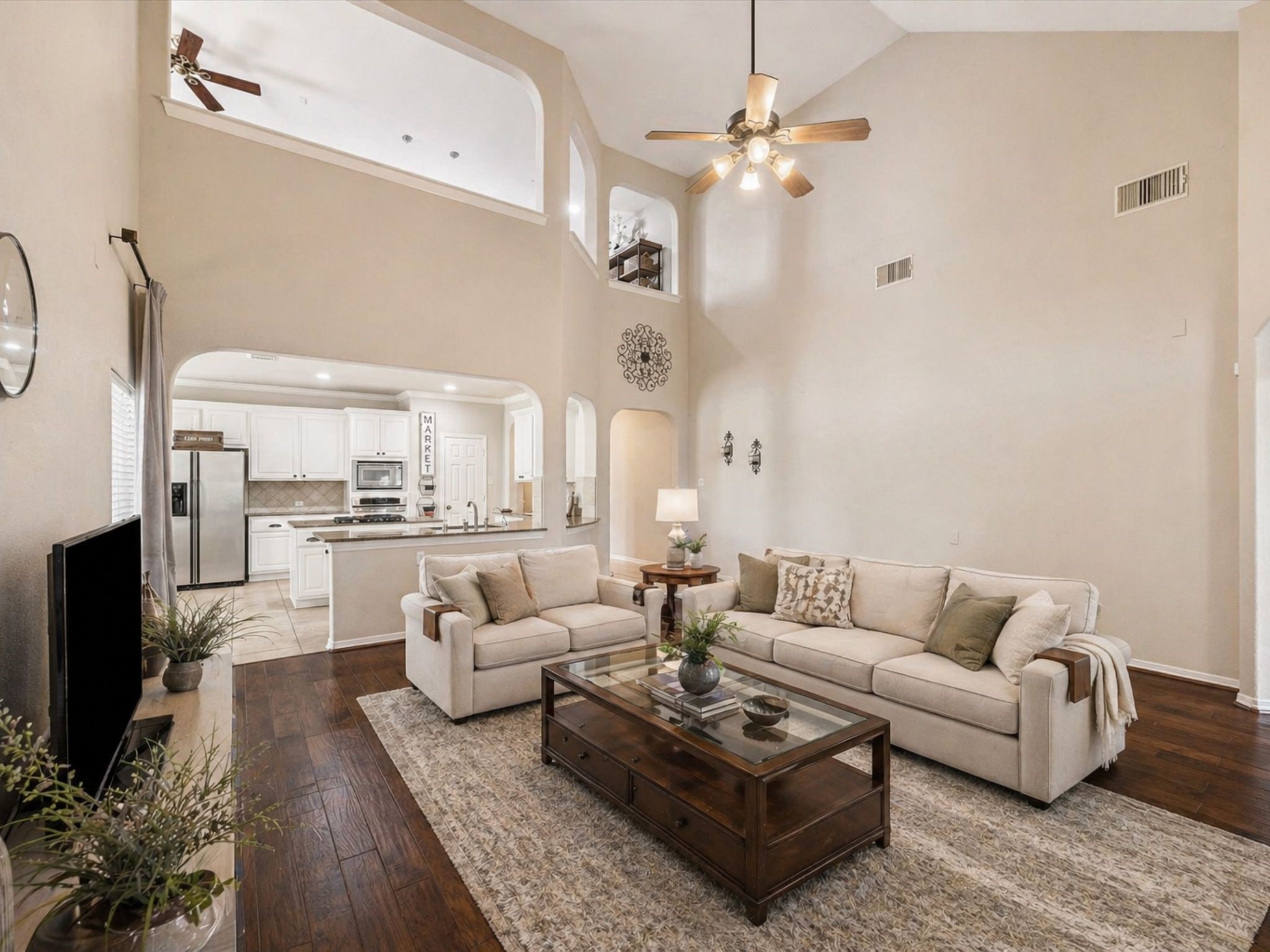 EXPANSIVE LIVING AREA WITH HARDWOOD FLOORS AND VAULTED CEILINGS, OFFERING FLEXIBLE LAYOUT OPTIONS. **Virtually Staged.