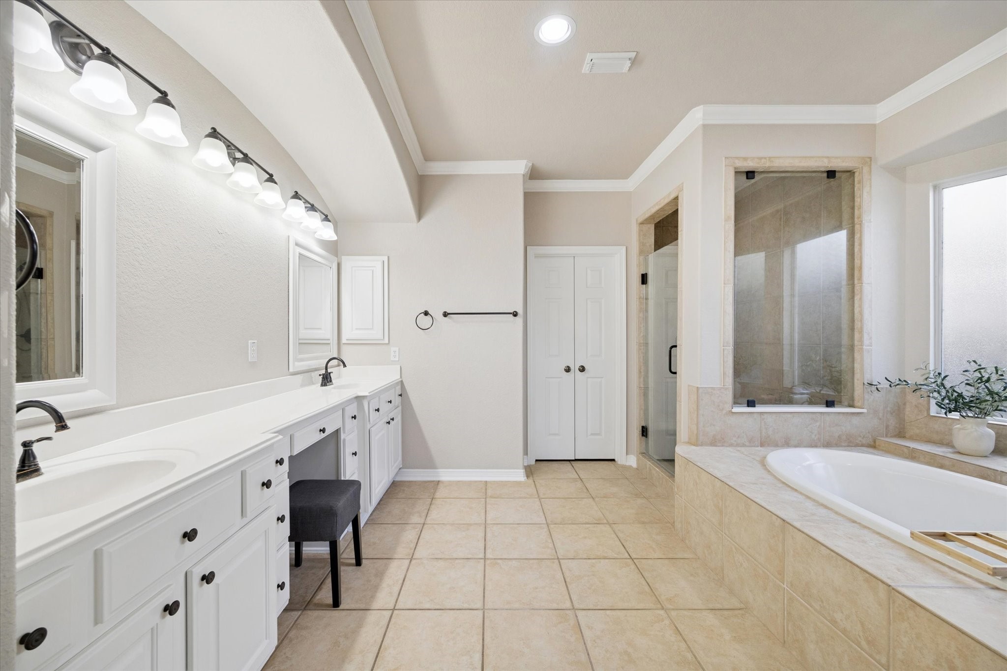 SPACIOUS PRIMARY BATH WITH DUAL VANITIES, EXTENDED COUNTER SPACE, AND A LARGE WALK-IN SHOWER.