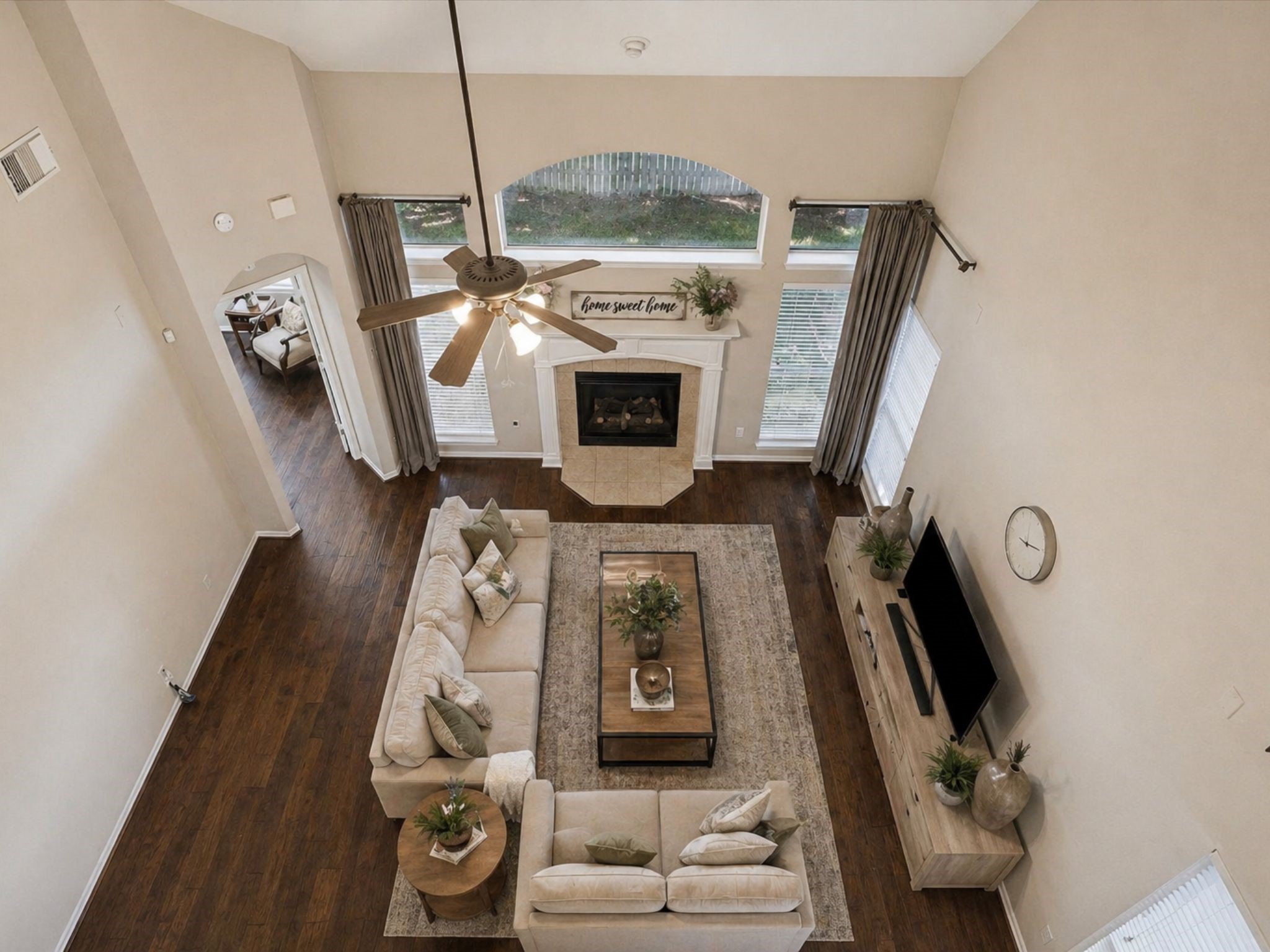 DRAMATIC TWO-STORY LIVING ROOM WITH SOARING CEILINGS, FLOOR-TO-CEILING WINDOWS, AND A CENTRAL FIREPLACE. OPEN LAYOUT PERFECT FOR ENTERTAINING. DRAMATIC TWO-STORY LIVING ROOM WITH SOARING CEILINGS, FLOOR-TO-CEILING WINDOWS, AND A CENTRAL FIREPLACE. OPEN LAYOUT PERFECT FOR ENTERTAINING.