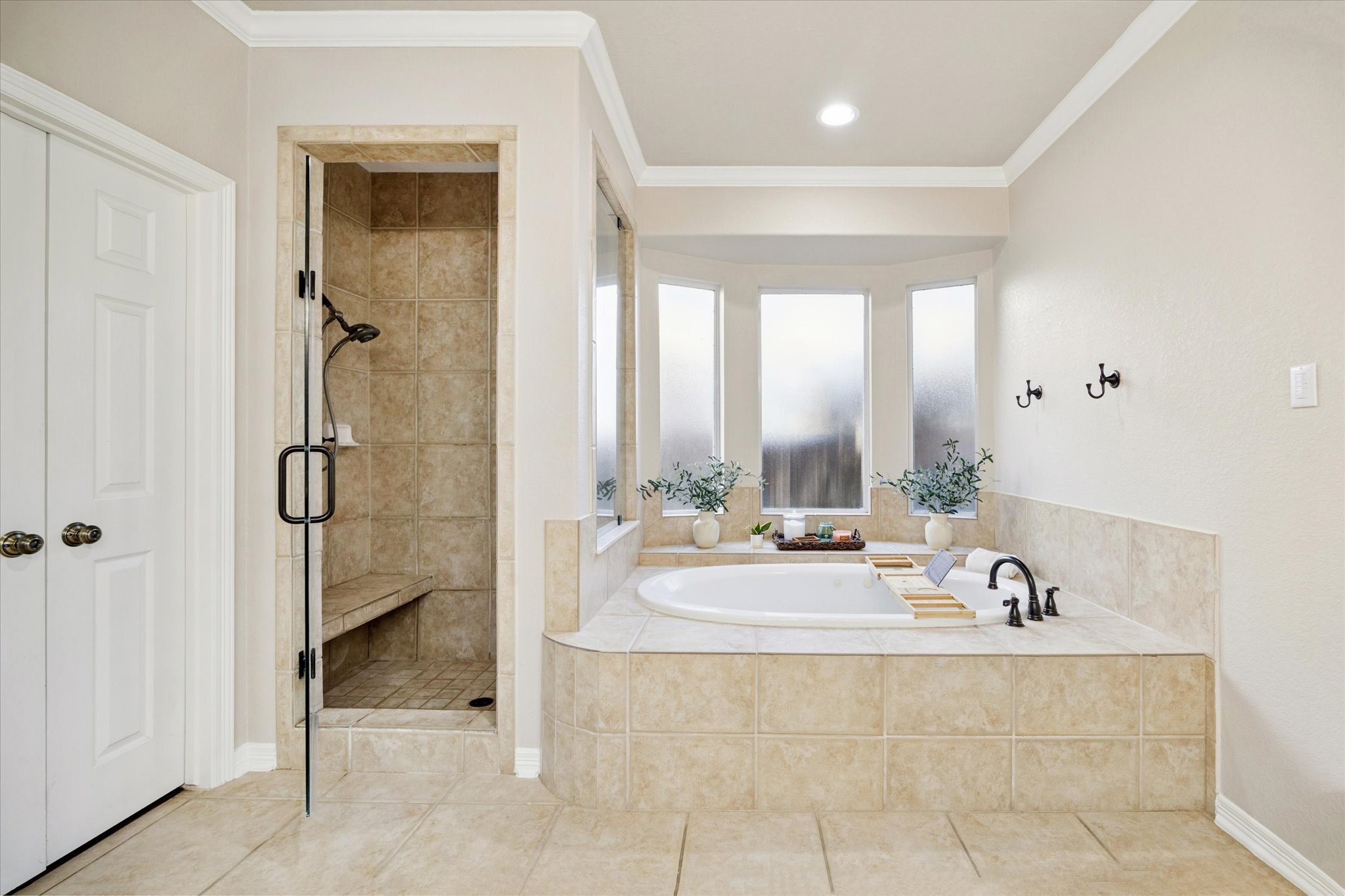 LUXURIOUS SOAKING TUB WITH SEPARATE WALK-IN SHOWER AND NATURAL LIGHT FROM FROSTED WINDOWS FOR PRIVACY. A TRUE SPA-LIKE RETREAT.