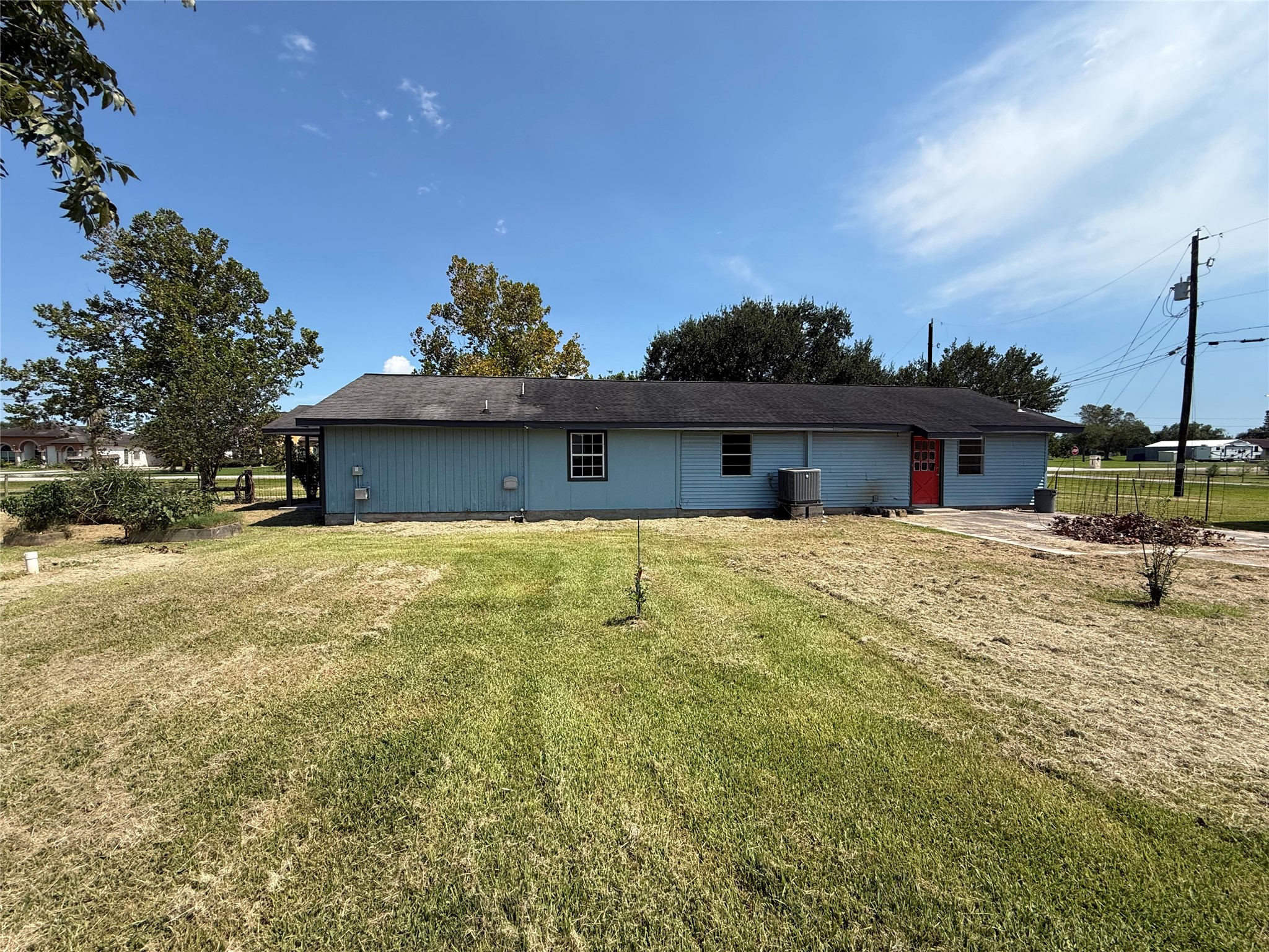 Rear exterior overlooking the open backyard and concrete patio.