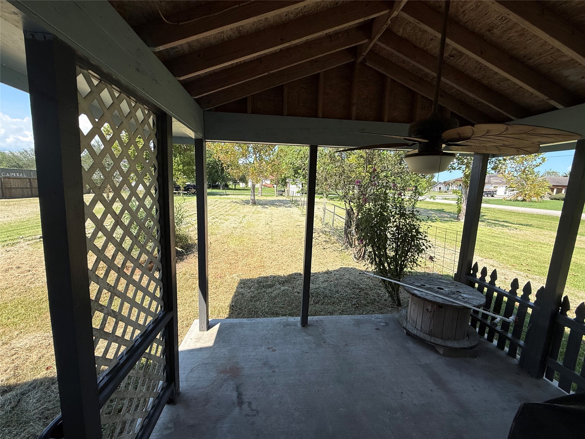 Covered side porch with views of the surrounding yard.