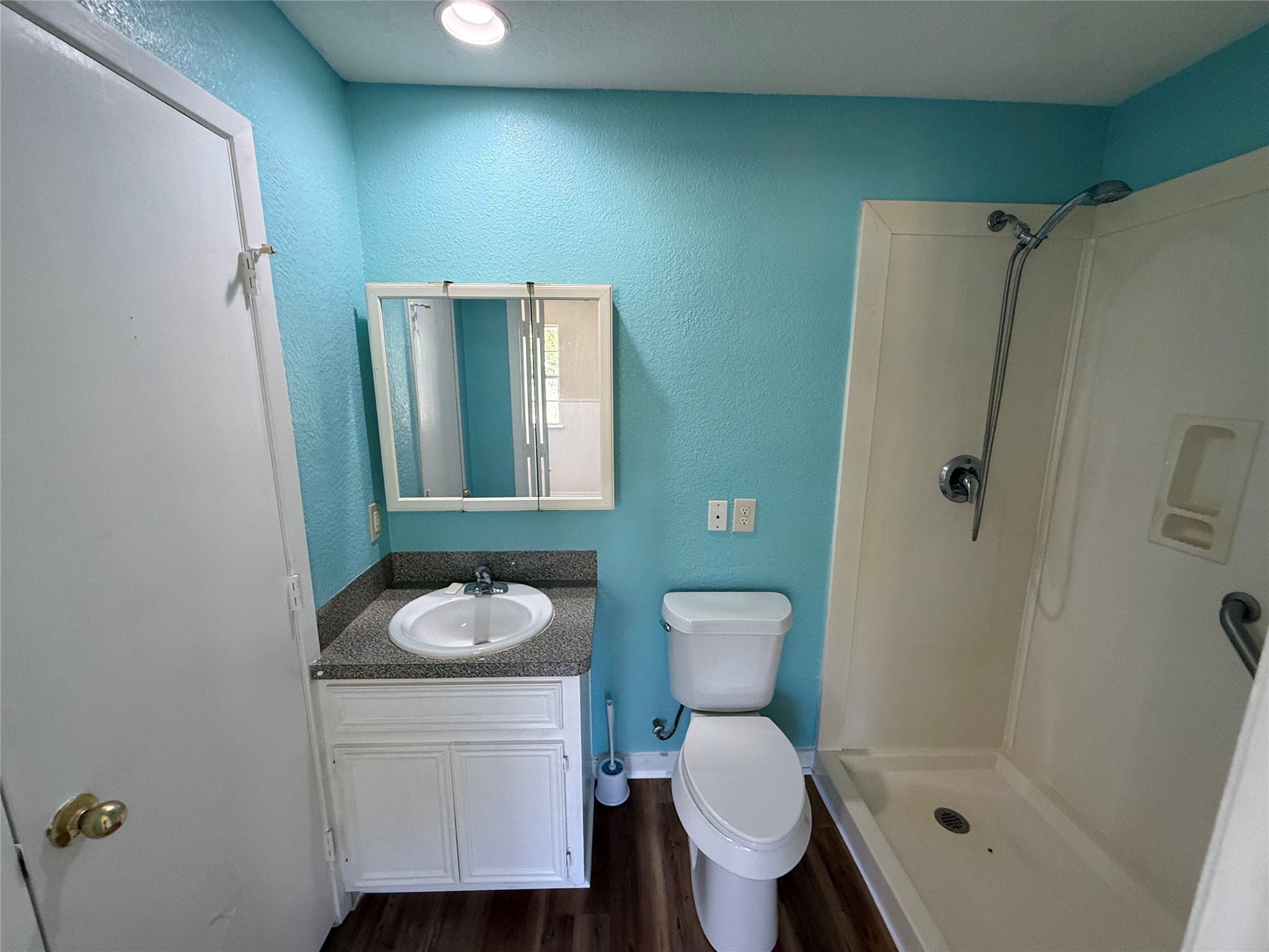 Bathroom featuring a white vanity, mirrored cabinet, and tub/shower combination.