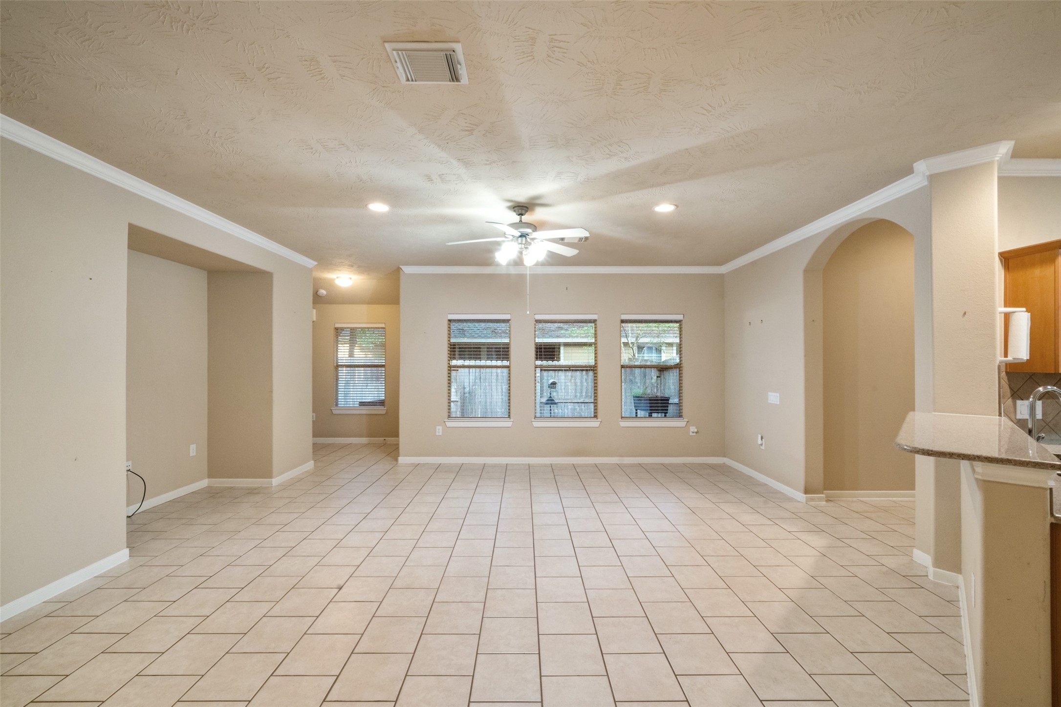 Spacious living room with bright windows, ceiling fan and entertainment nook
