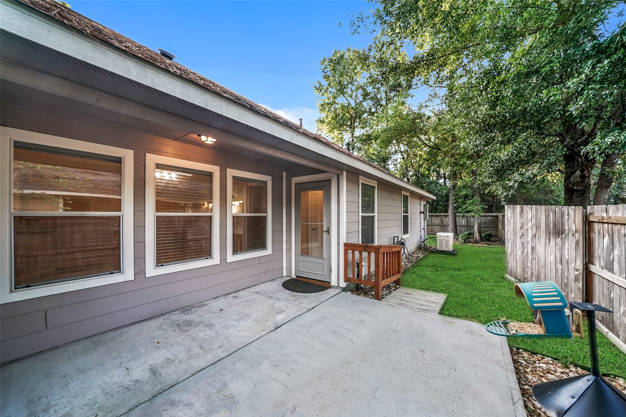 Covered patio with extended space that is equipped with a ramp and handrail to the back yard.