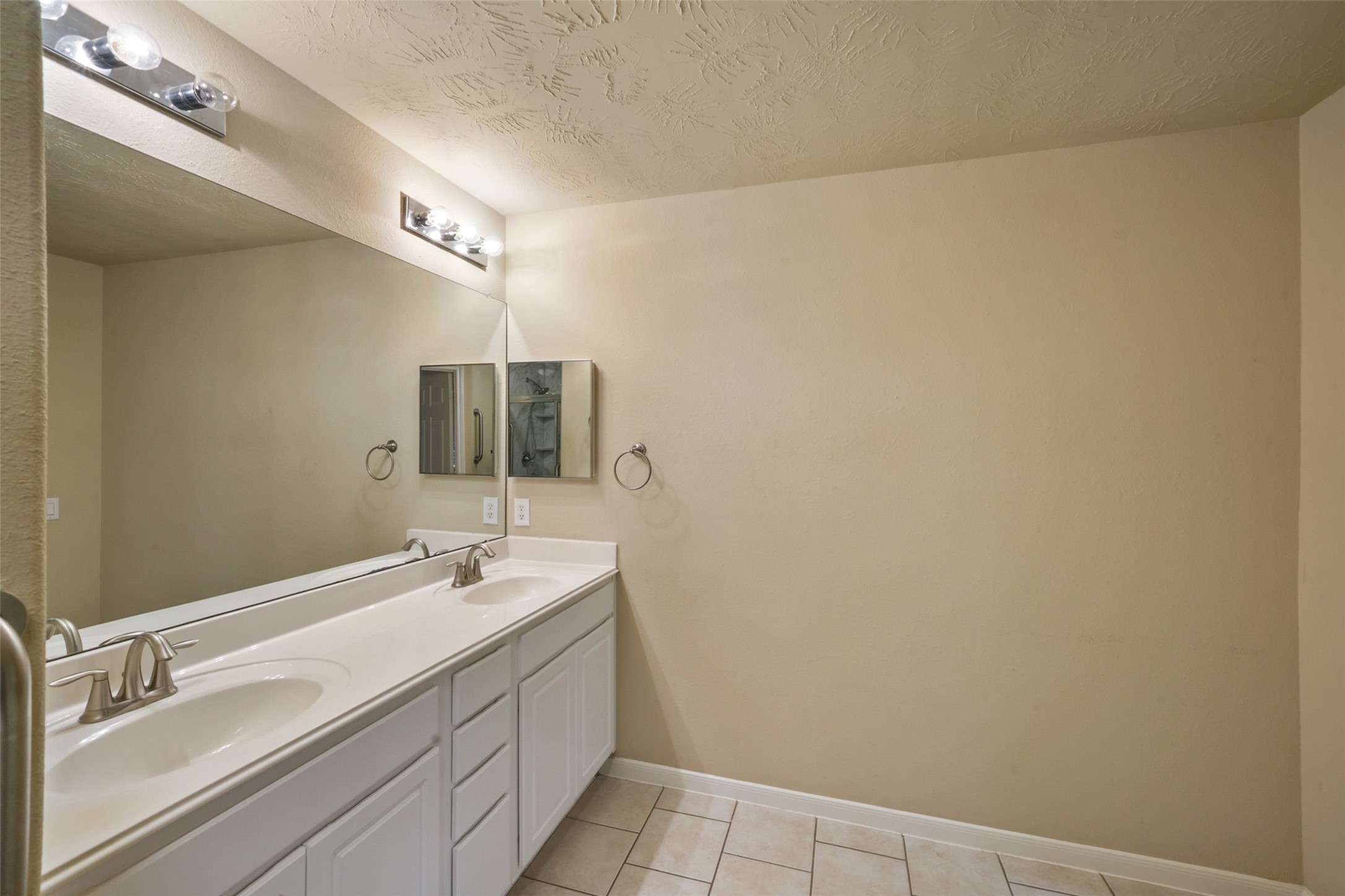 Large area with double sinks, cabinet space, drawers and mirrored medicine cabinet.