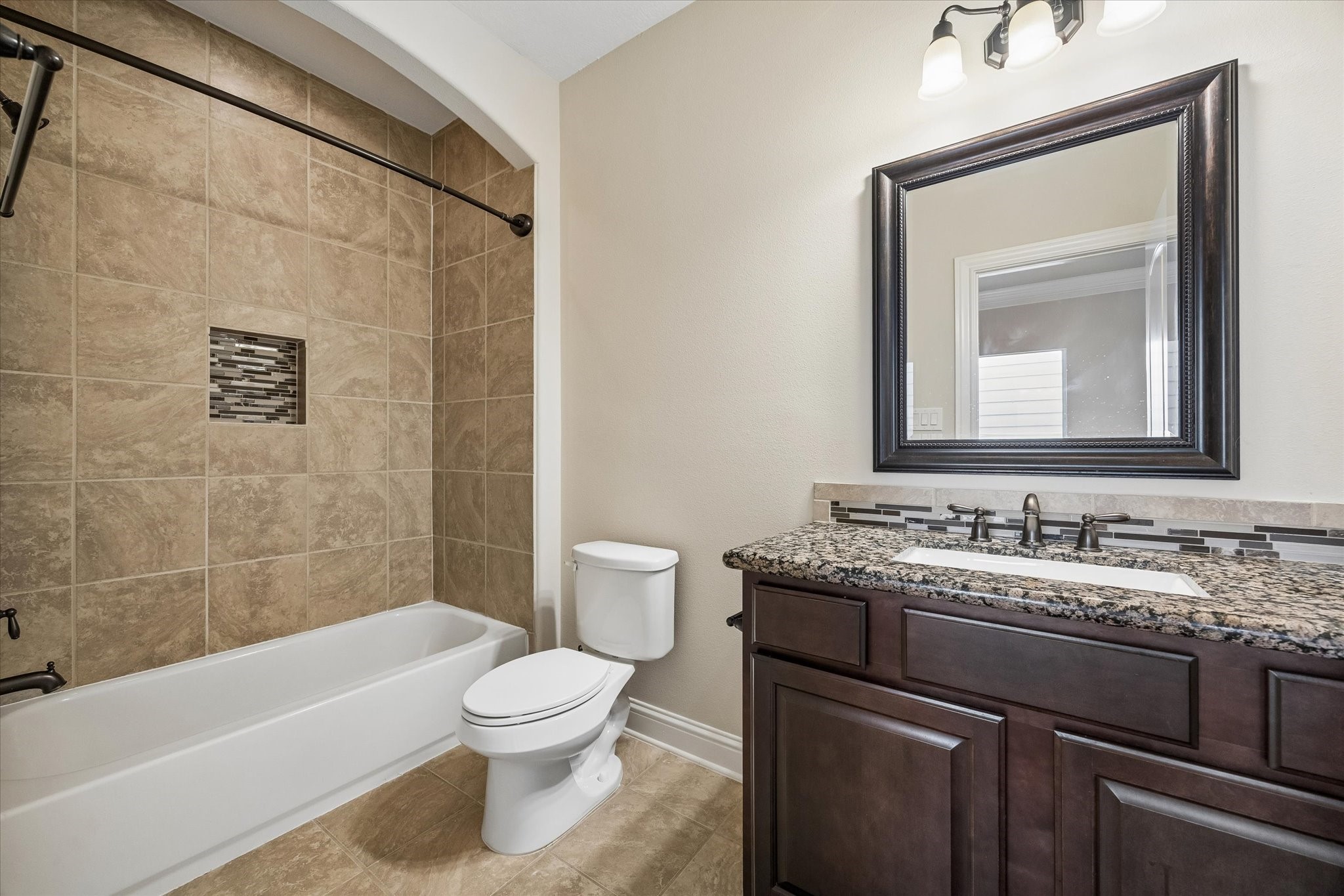 Full bathroom with vanity storage and tub-shower combination.