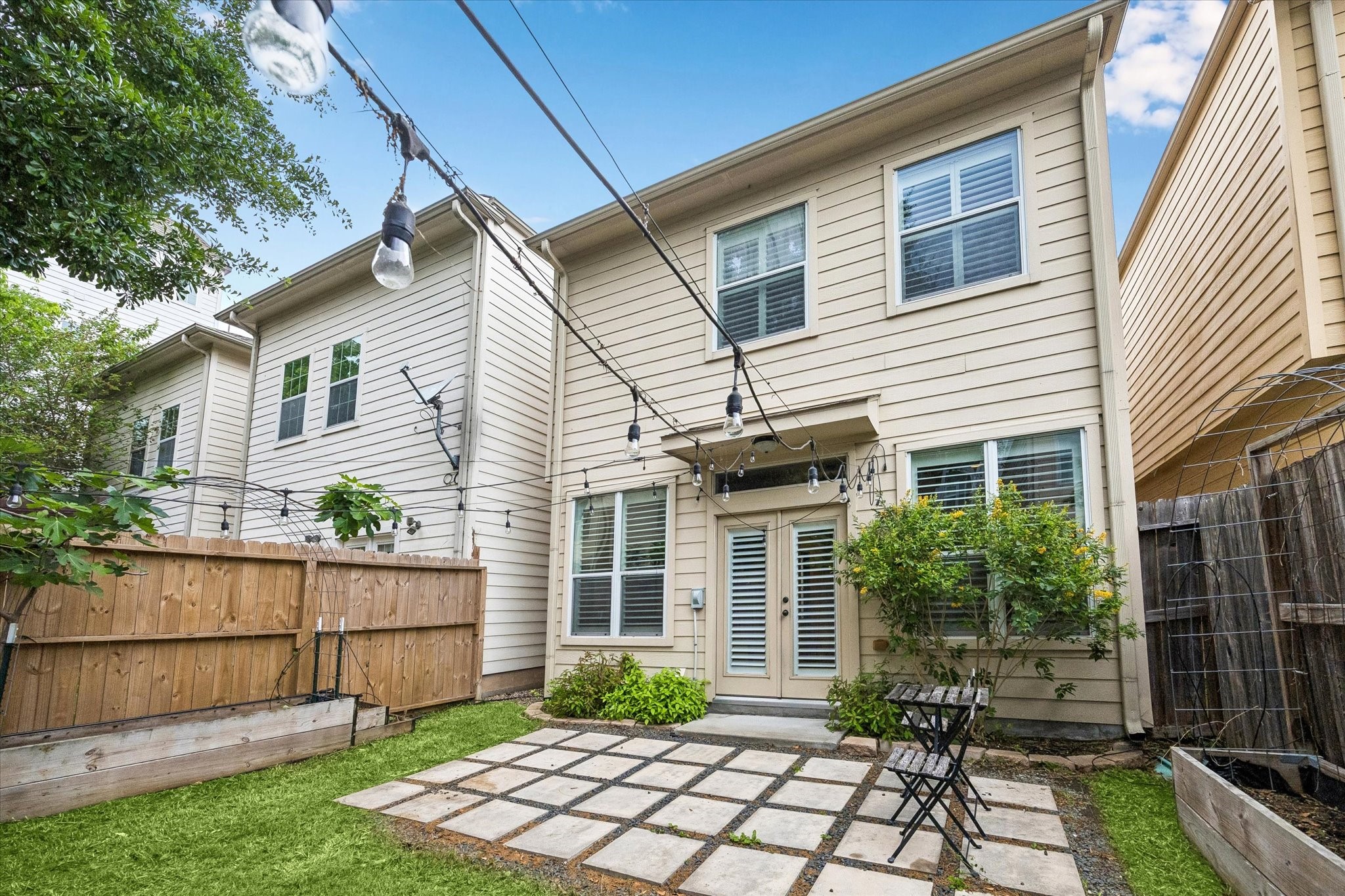 Rear exterior view showcasing fenced yard and inviting outdoor retreat.