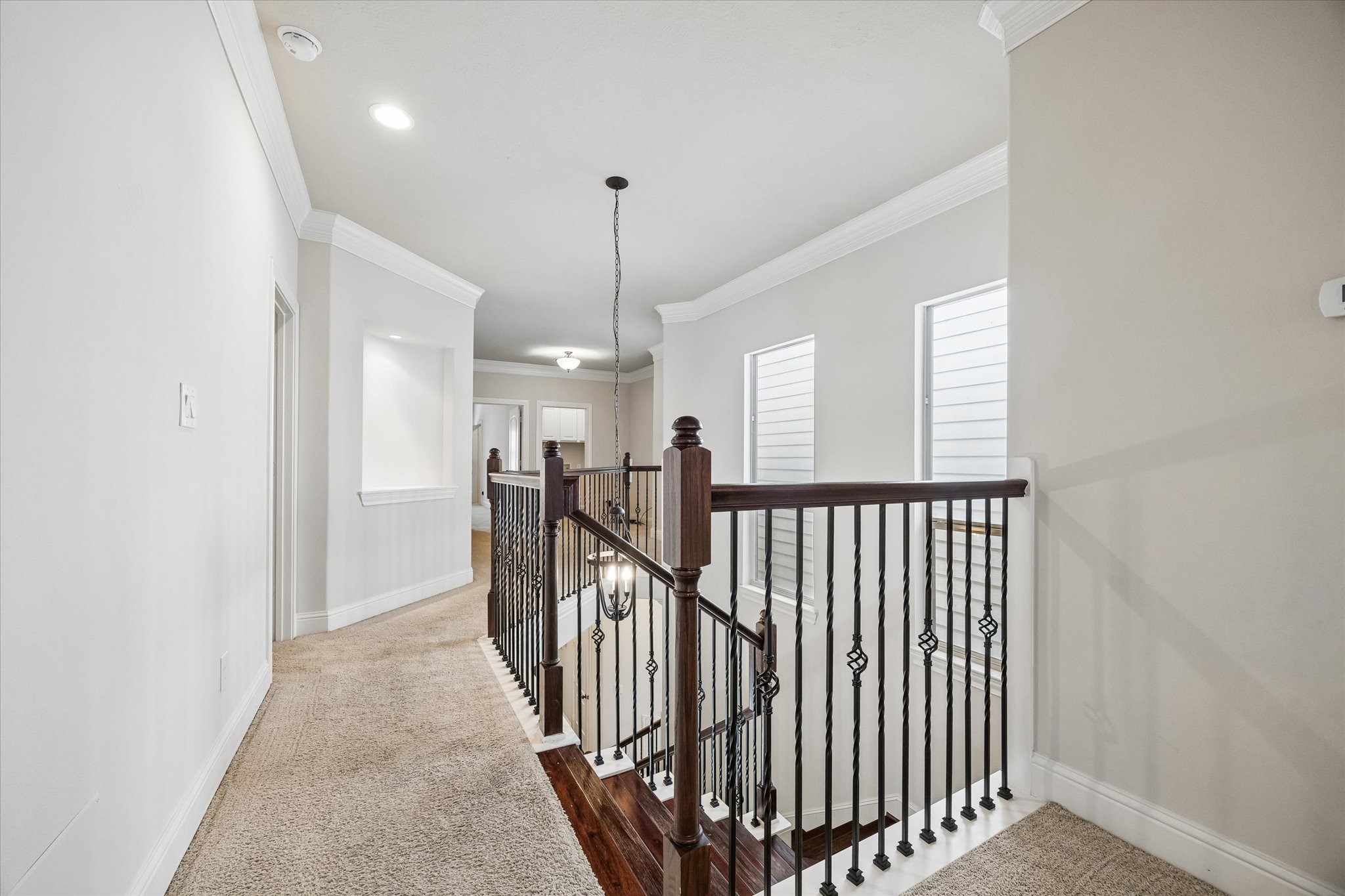 Upstairs landing with open railing and convenient access to secondary rooms.