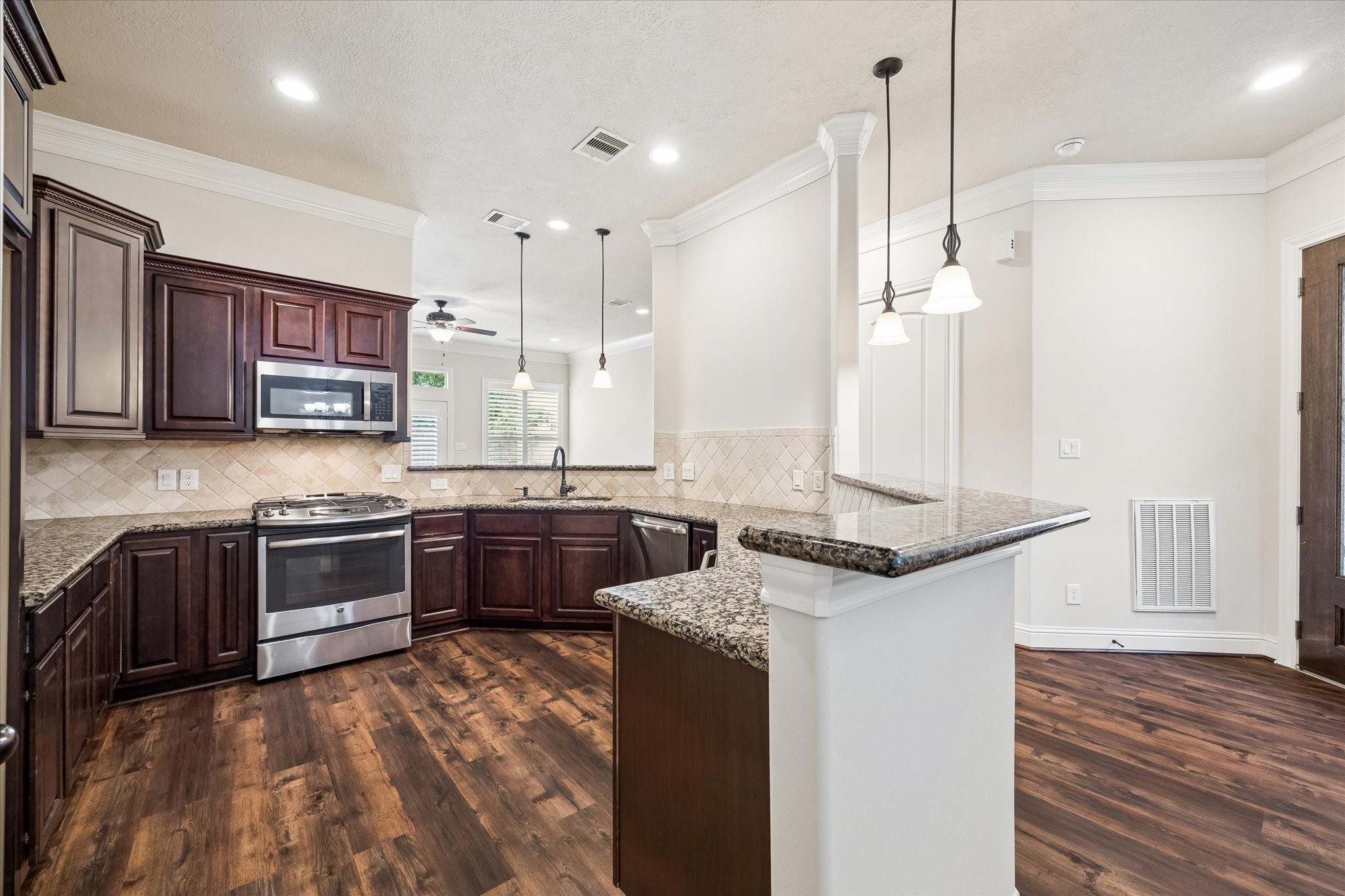 Stylish kitchen with breakfast bar, ample cabinetry, and generous workspace.