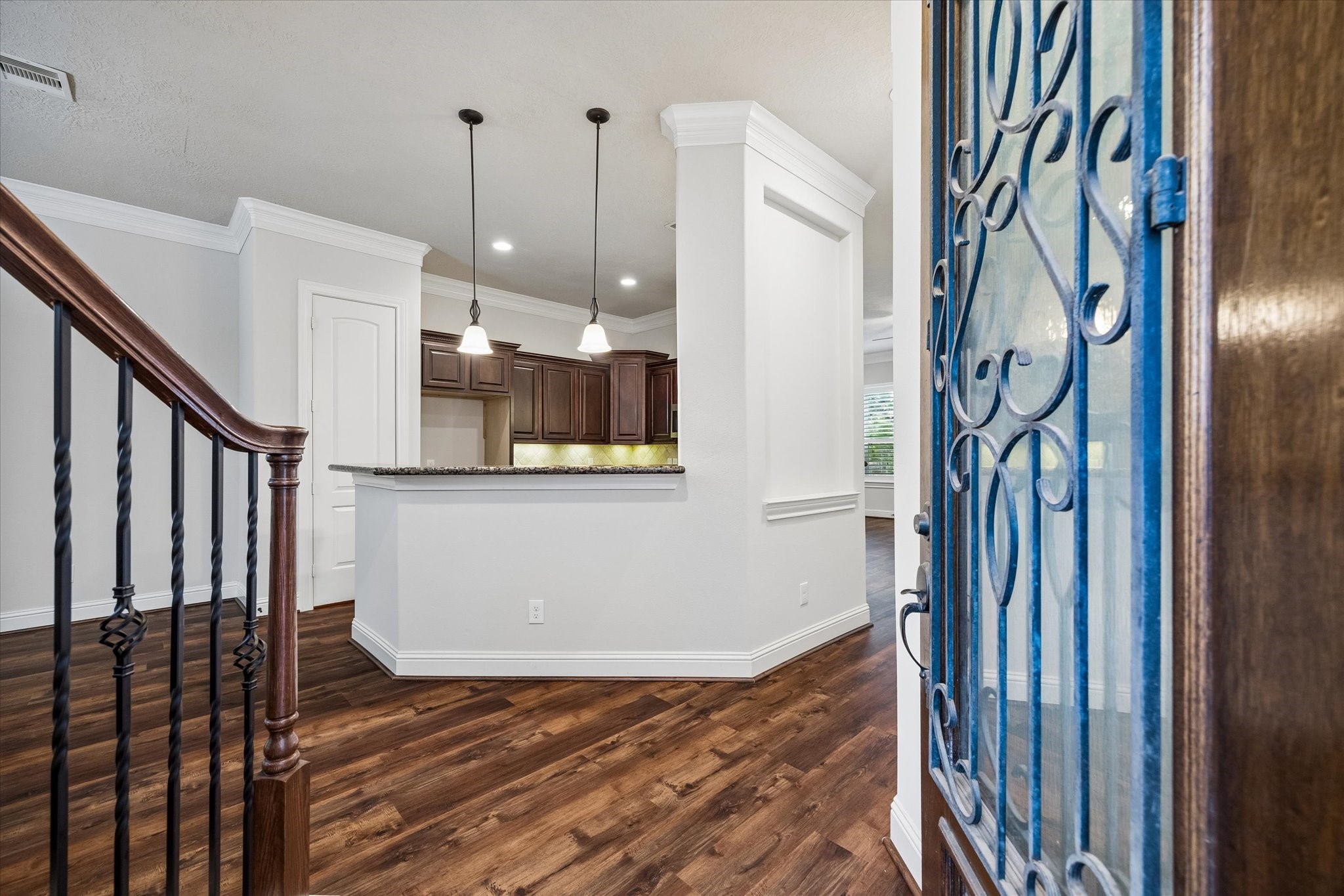 Welcoming entry with open-concept design and elegant staircase details.