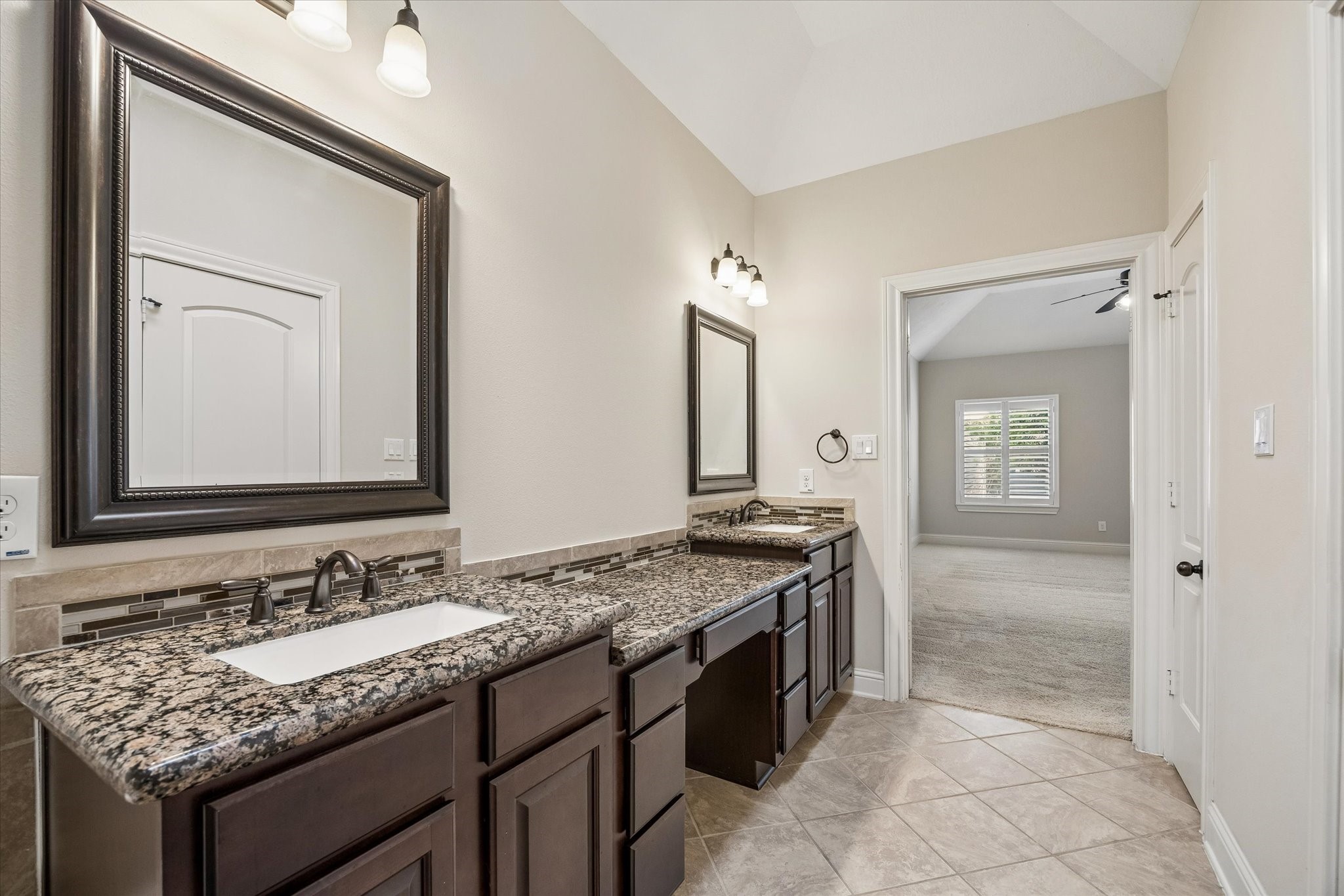 Primary bath featuring double sinks, ample storage, and elegant finishes.