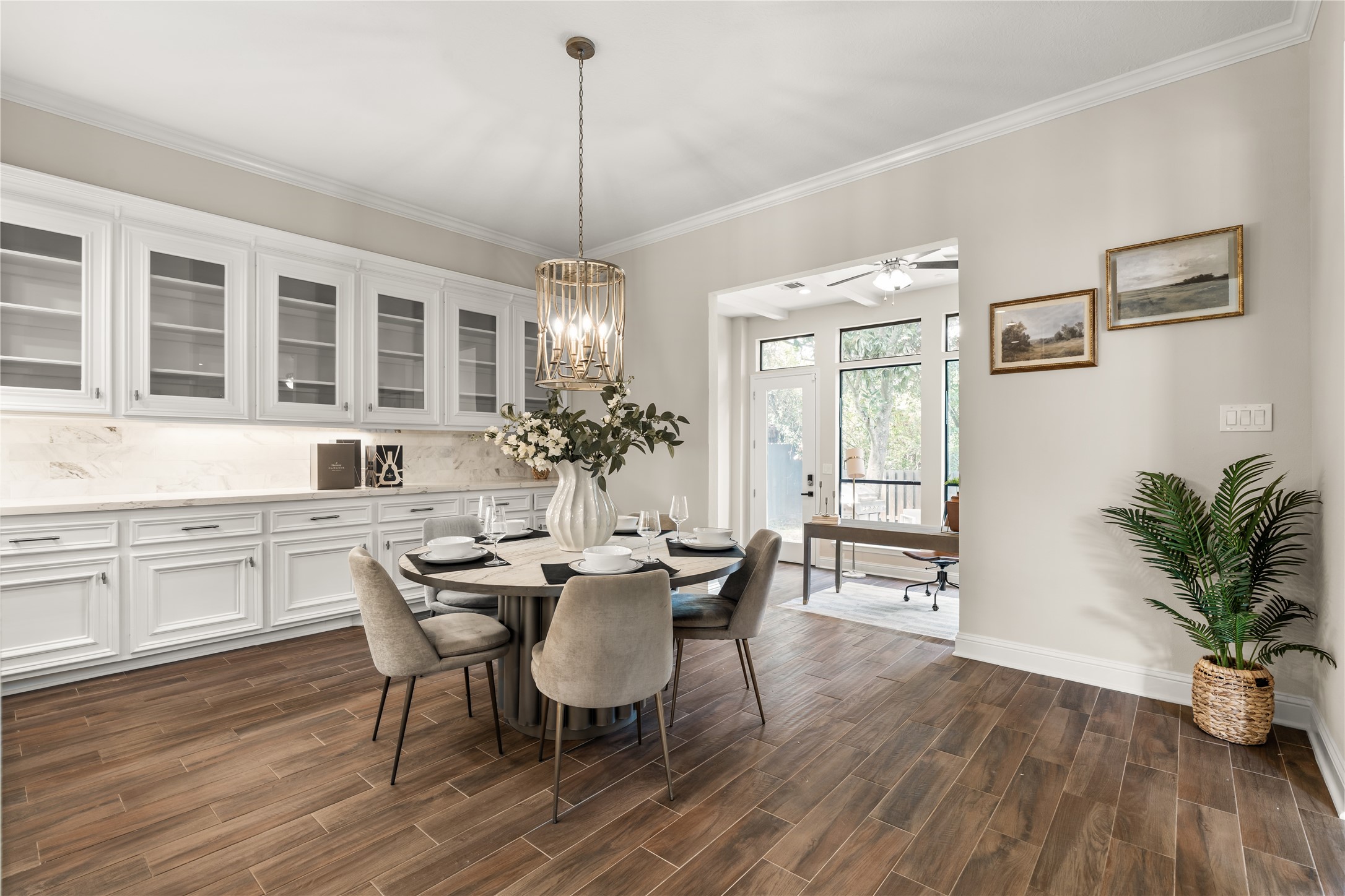 Elegant cabinetry, statement lighting, and warm flooring create an inviting breakfast room with an effortless connection to the kitchen.