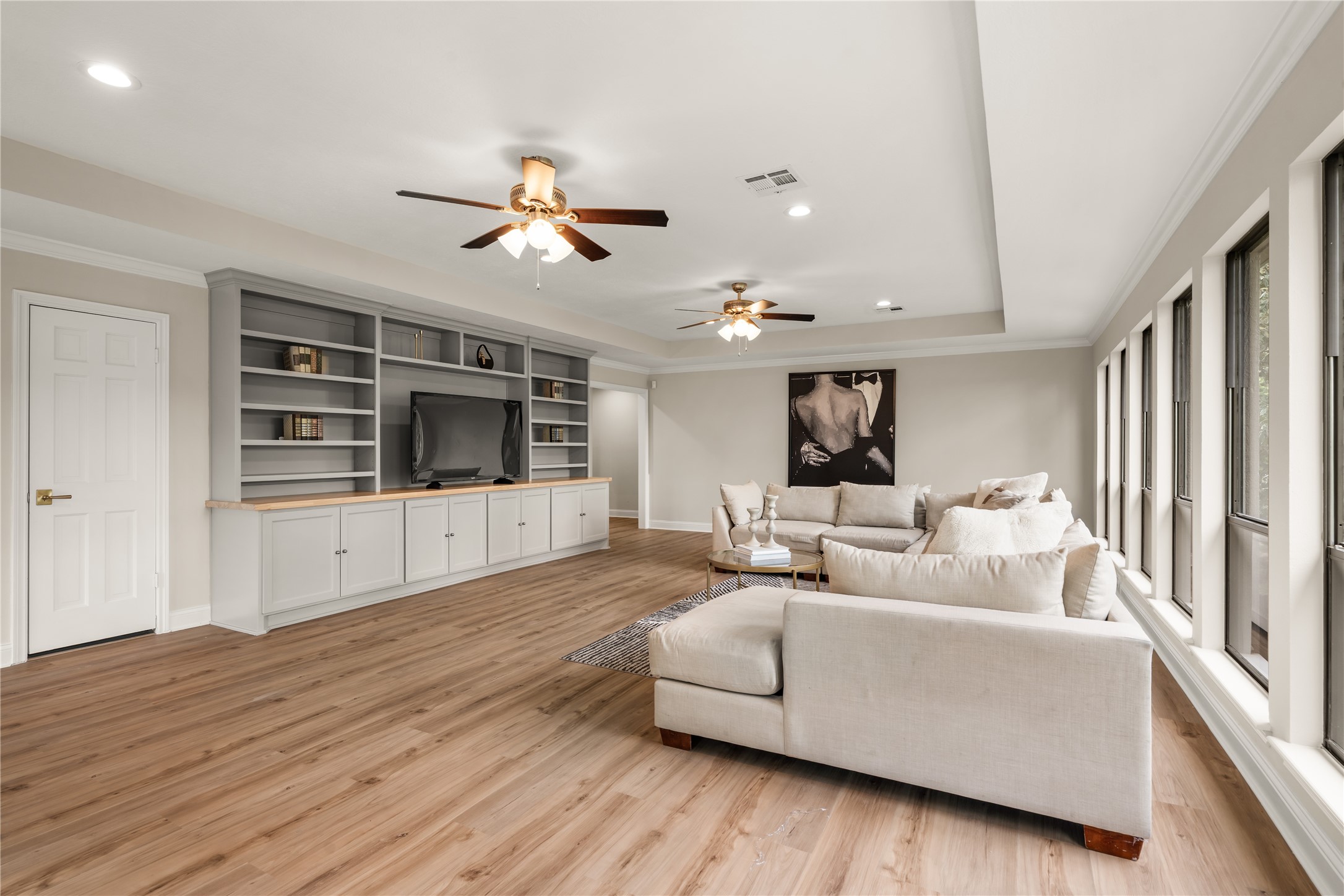 Designed as an elevated second living space, the upstairs family room features a newer media center, cabinetry, and bookshelves complemented by abundant windows and generous room for gathering.