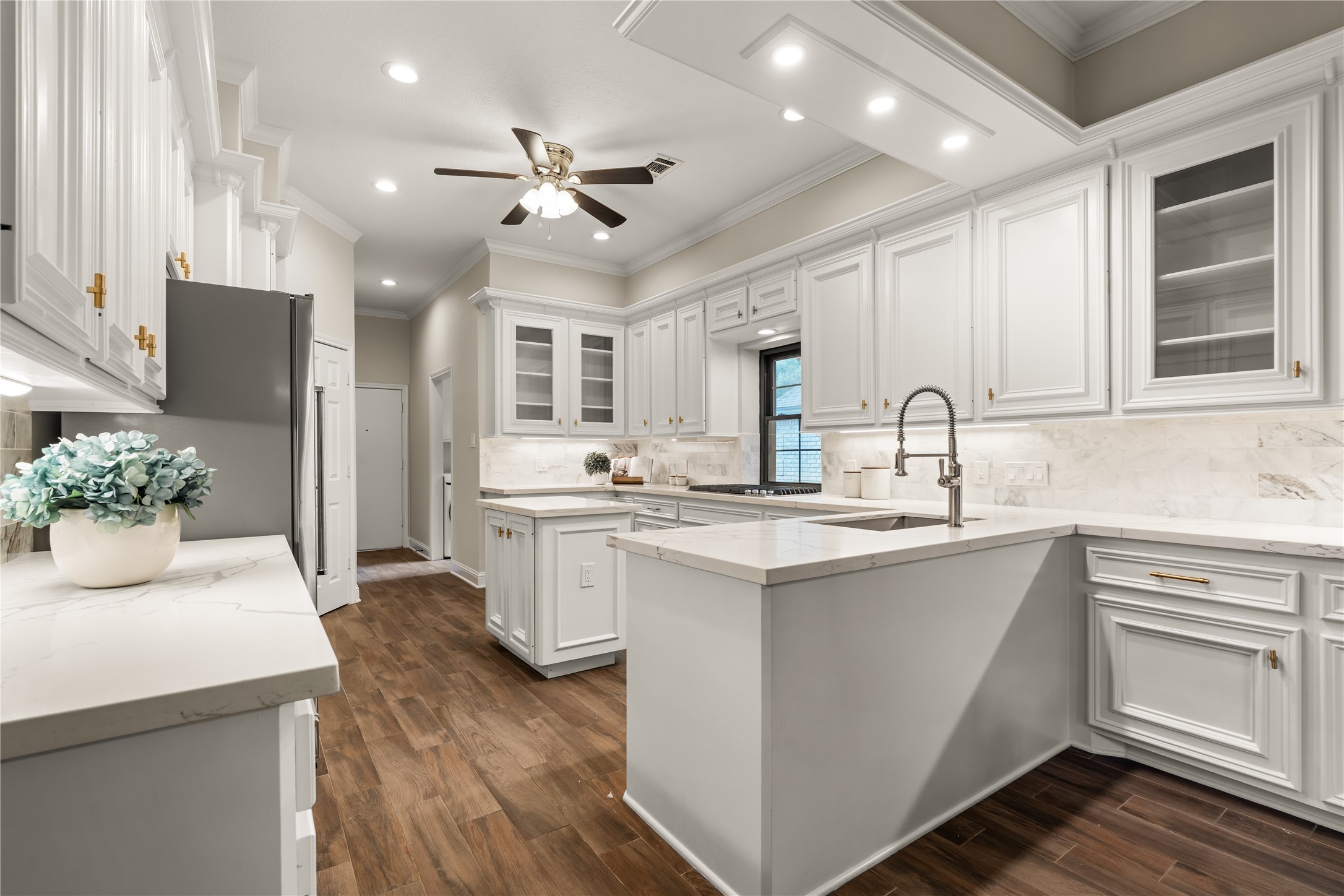 A spacious center island topped with elegant quartz countertops anchors the kitchen, providing generous prep space and a natural gathering place for casual dining and entertaining.