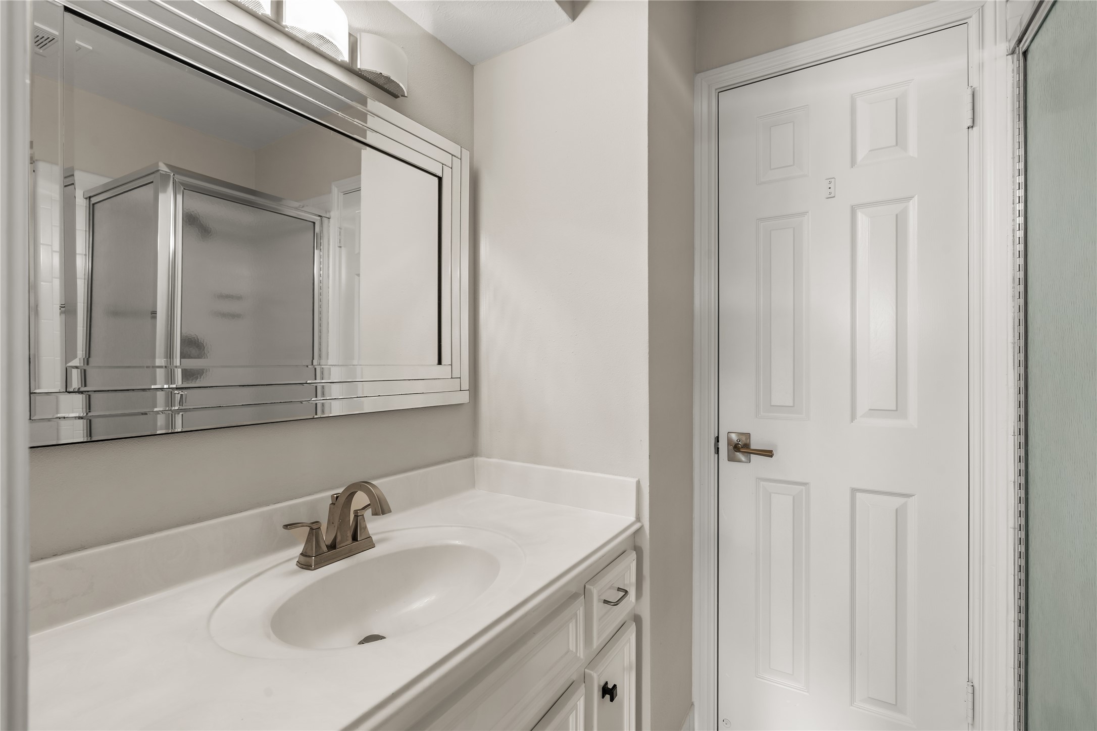 A beautifully arranged secondary bathroom features an extended vanity, generous counter space, and abundant cabinetry for effortless everyday organization.