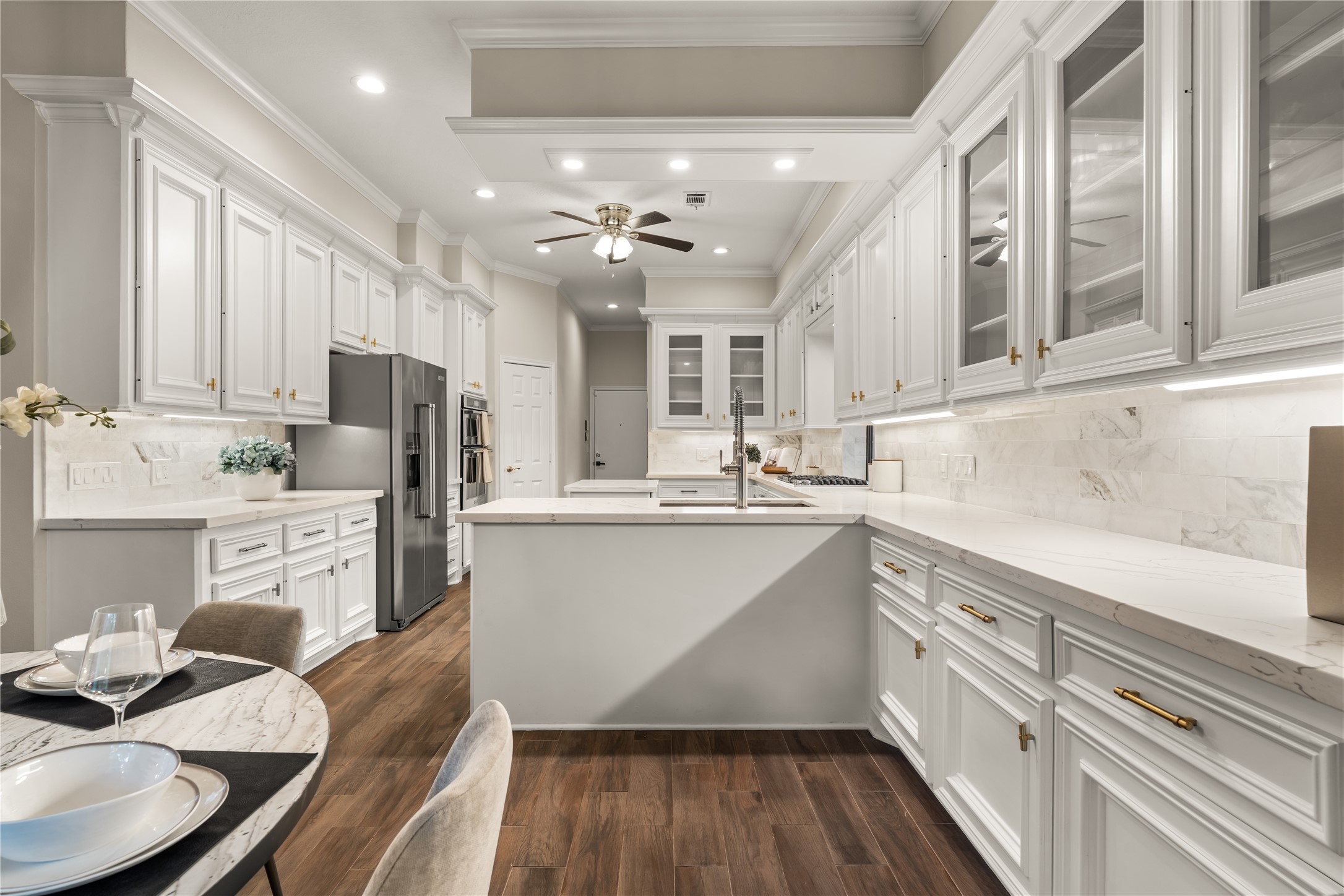 Crisp white cabinetry creates a bright, timeless aesthetic, while an abundance of storage and generous counter space offers exceptional functionality for both everyday living and entertaining.