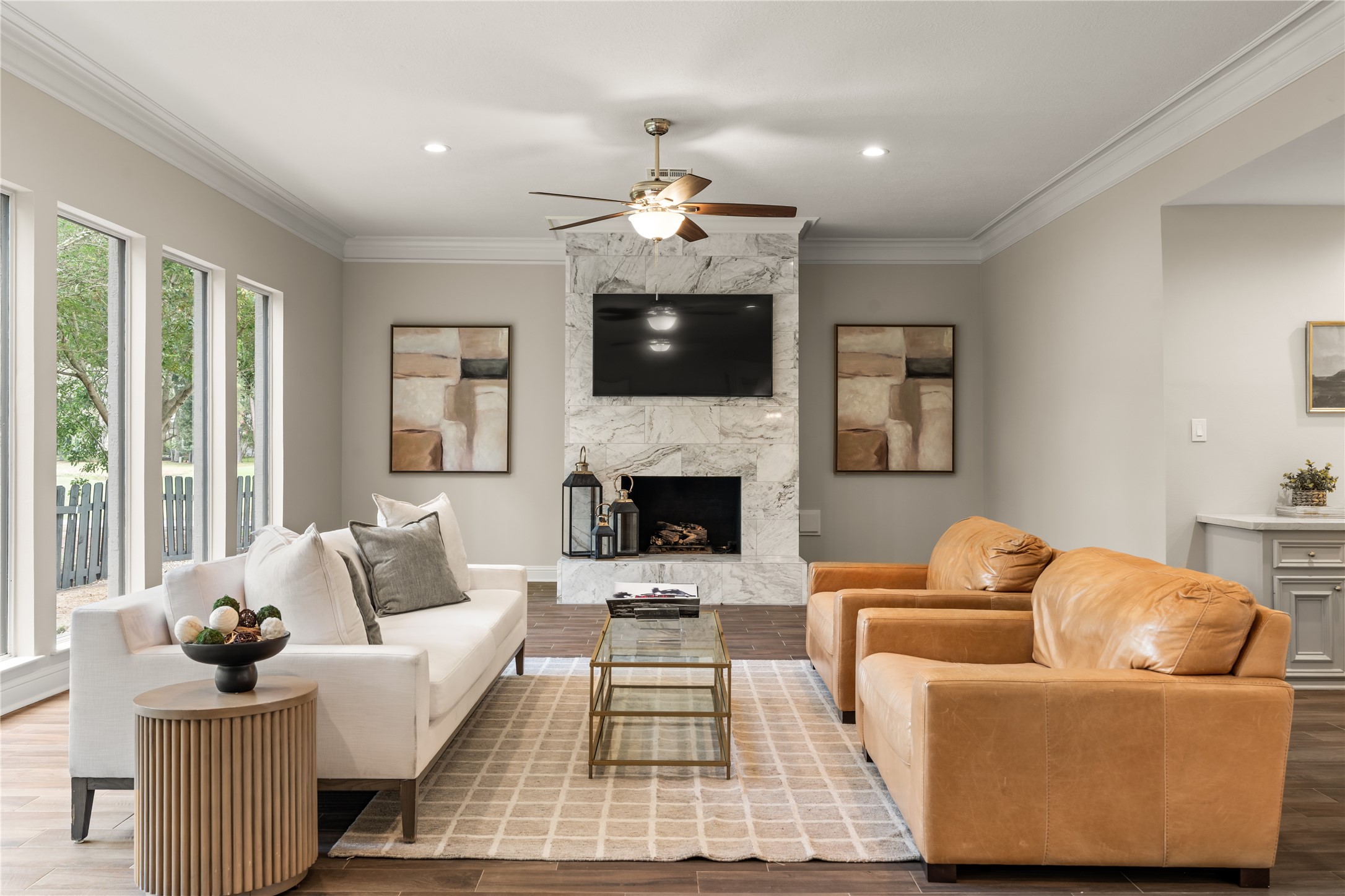 Designed for gracious everyday living and entertaining, this spacious gathering room pairs a statement fireplace with abundant natural light and warm finishes.