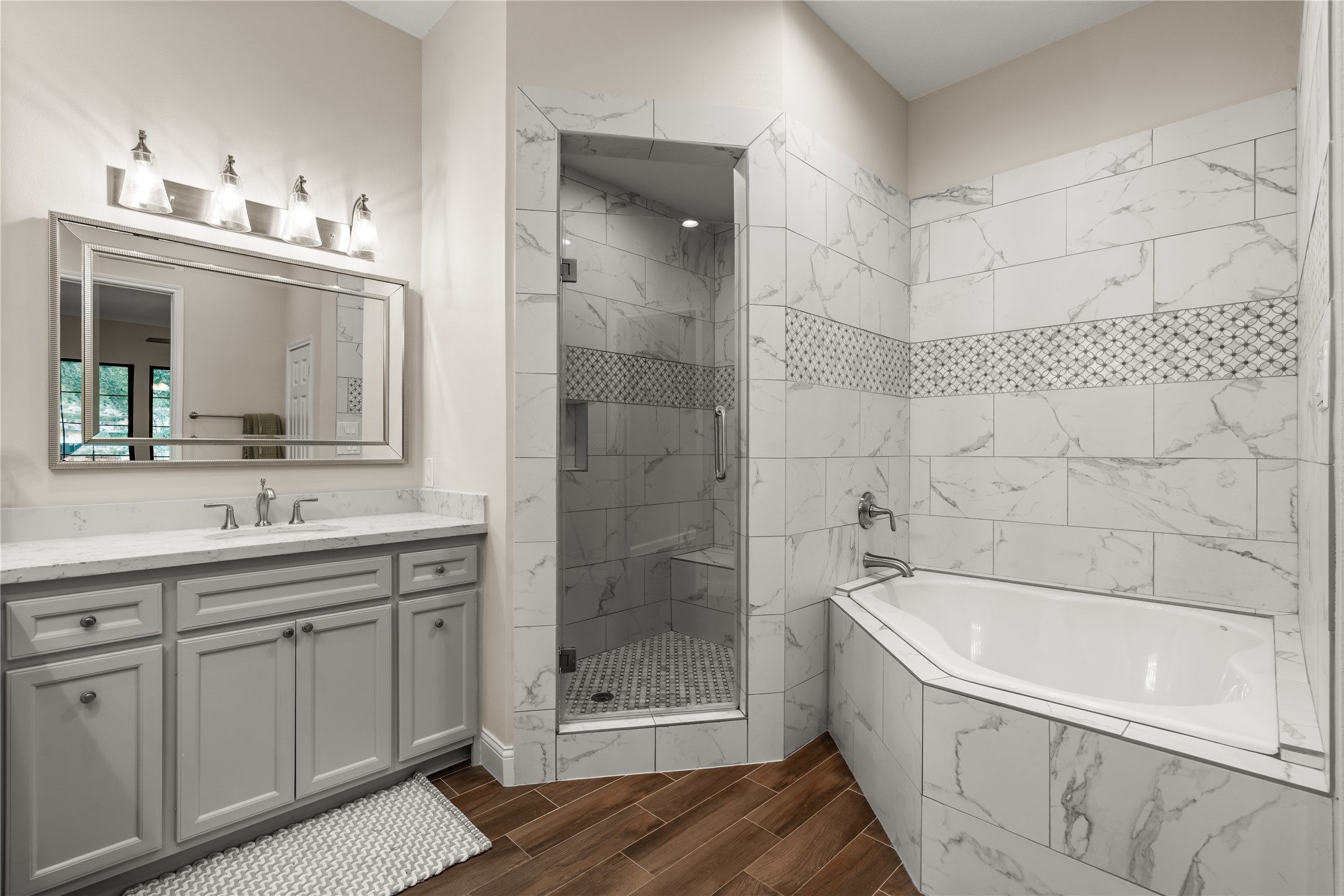A spa-inspired retreat complete with a soaking tub, separate glass-enclosed shower, and decorative tile work.