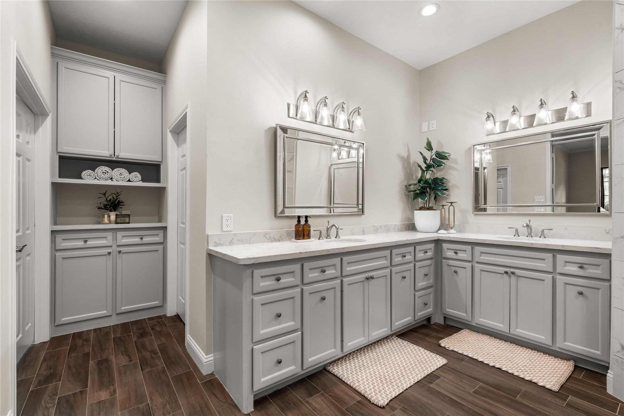 Well appointed primary ensuite featuring dual vanities, generous counter space, abundant cabinetry, and a dedicated built-in storage area.