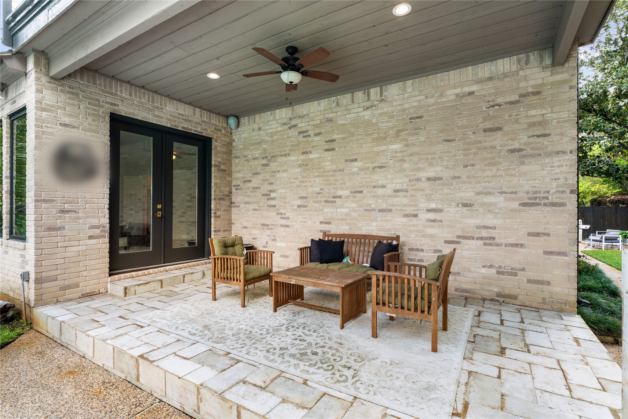 A spacious covered patio extends the home's living space outdoors with a ceiling fan, recessed lighting, and direct access to the interioran inviting setting for relaxing or entertaining beside the pool.