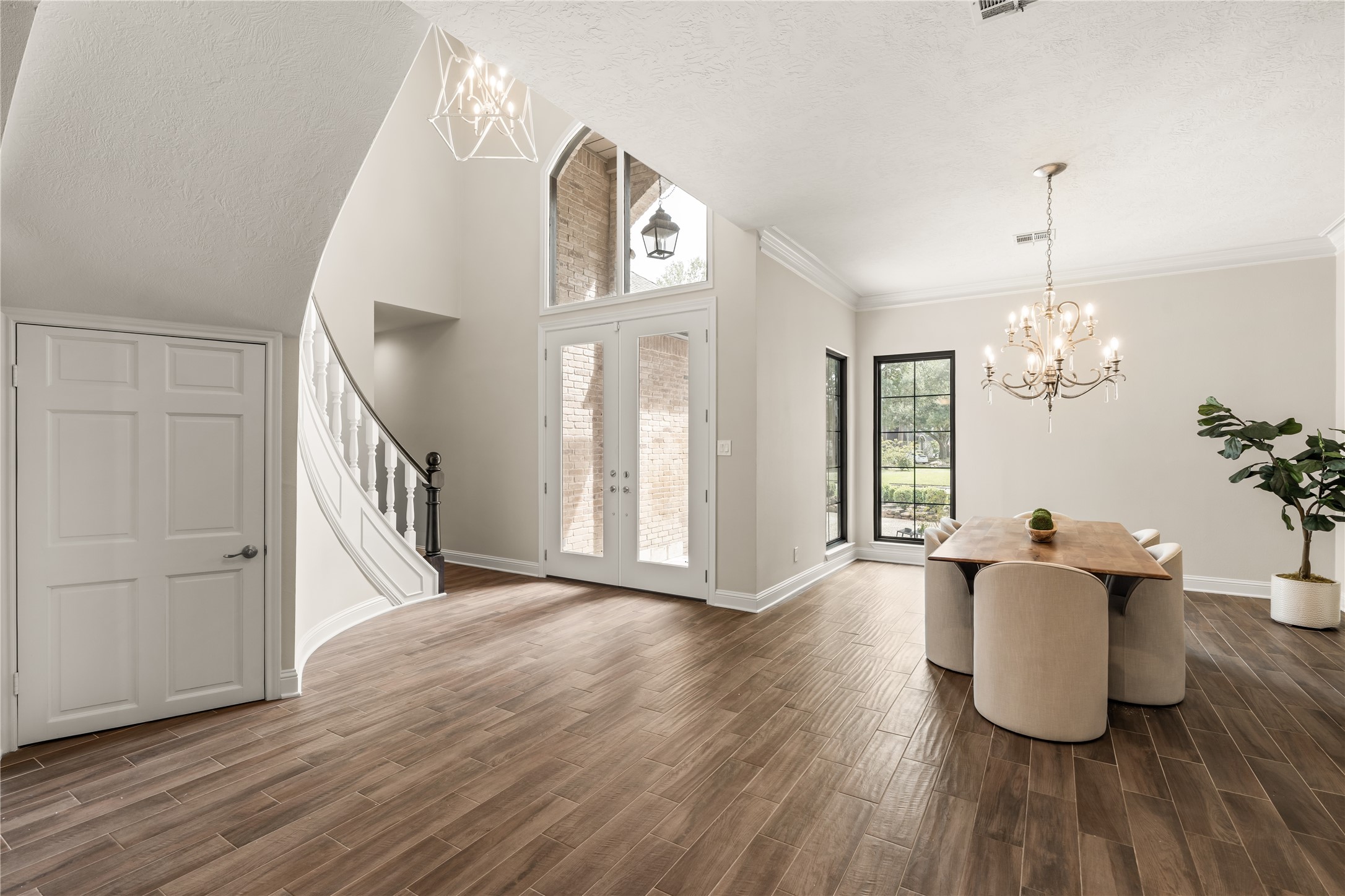 The renovated first floor welcomes you with soaring ceilings, a graceful curved staircase, refined architectural details, and an elegant dining space filled with natural light.