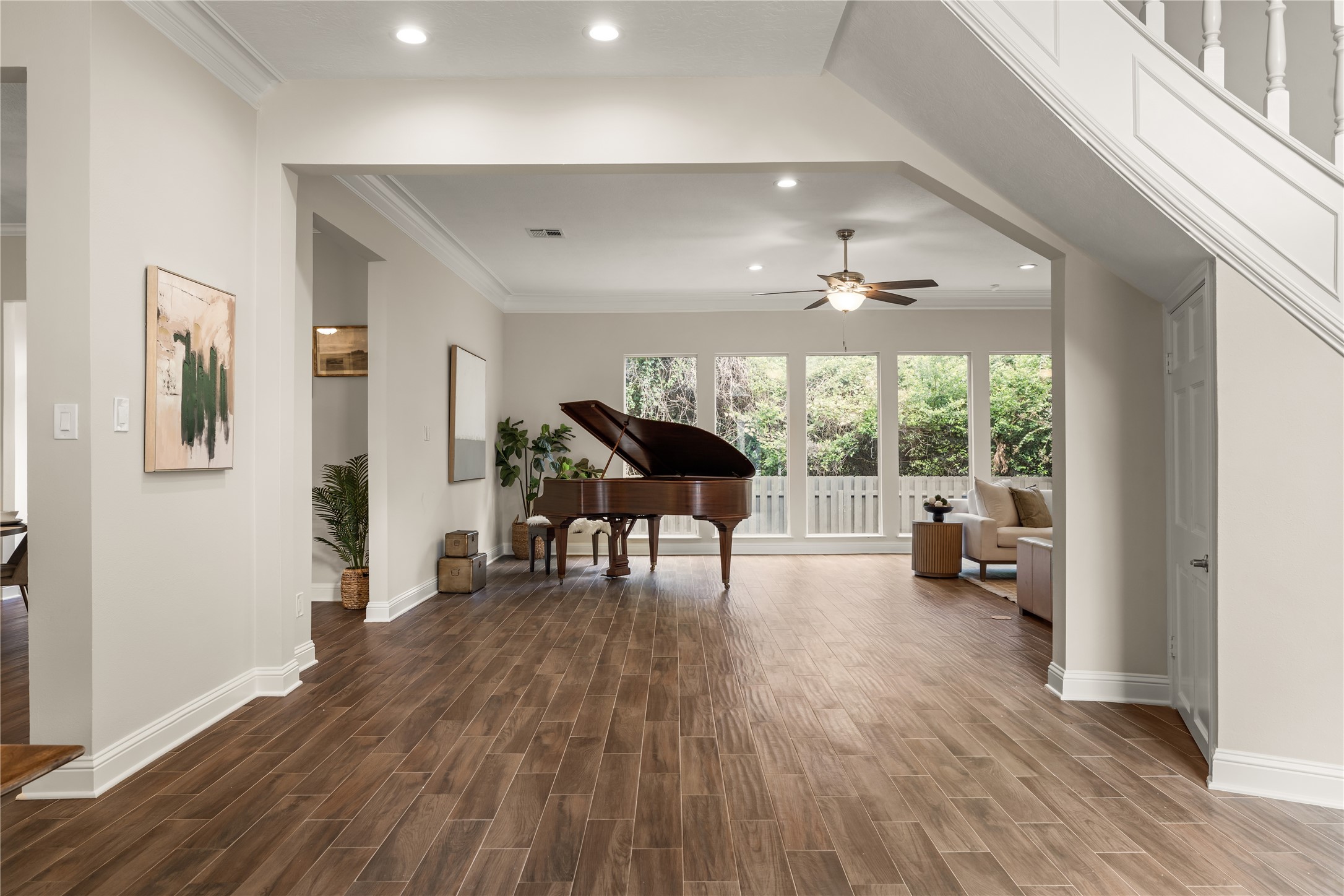 The elegant foyer opens gracefully into the expansive living room, where soaring proportions, abundant natural light, and a grand piano create a sophisticated sense of arrival.