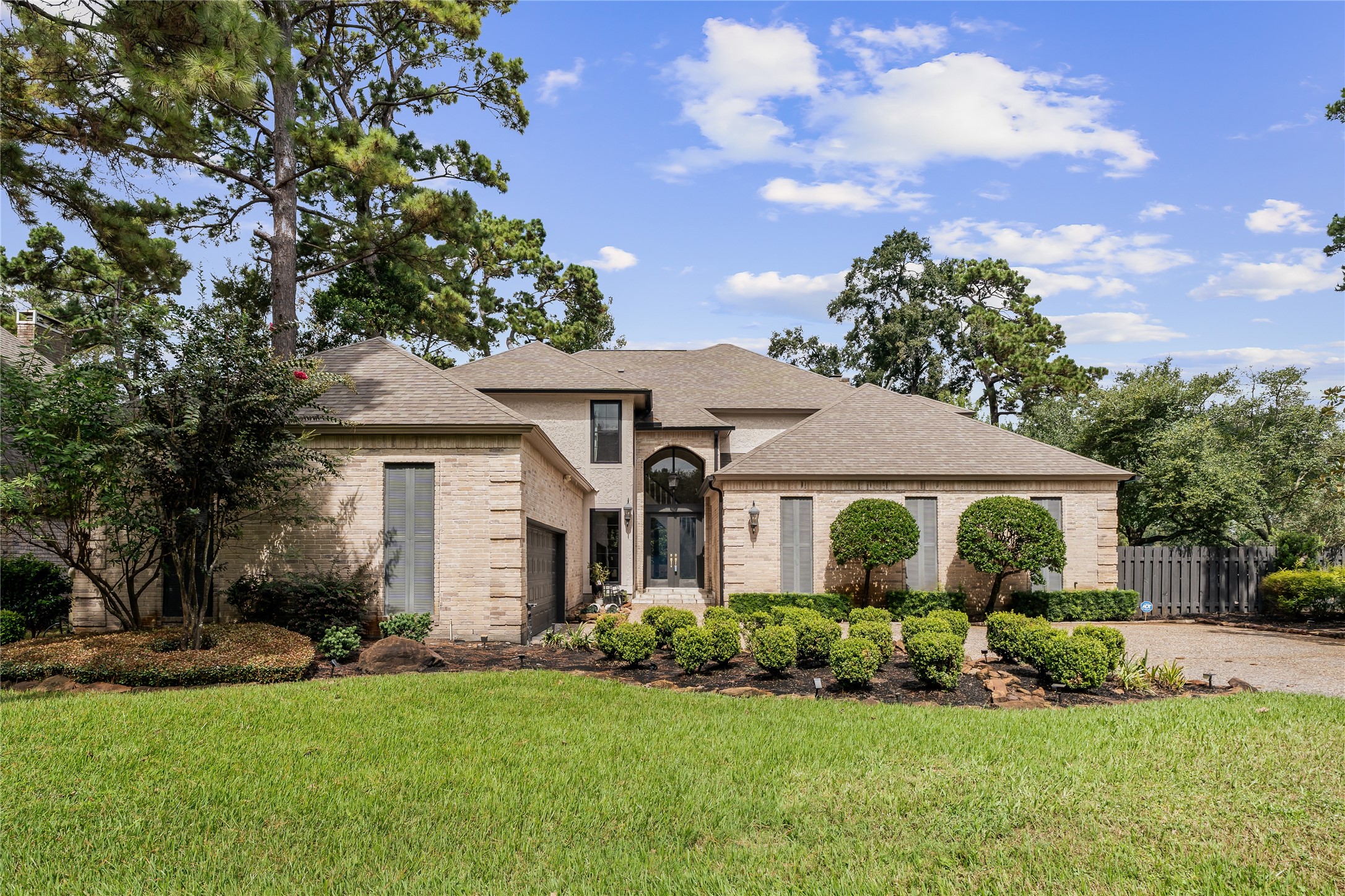 Welcome to 4719 Breezy Point Dr, where classic architecture meets thoughtful updates, including new exterior doors and hardware, all framed by manicured landscaping and mature trees.