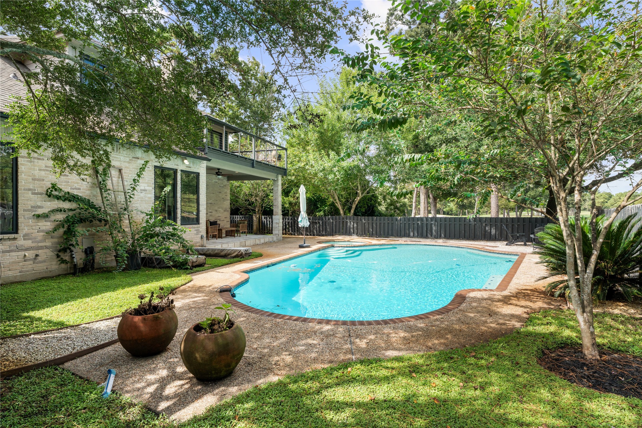 Lush greenery and mature trees surround the pool and spa, creating a private outdoor retreat with multiple areas for lounging, entertaining, and enjoying the comfort of no side neighbors.