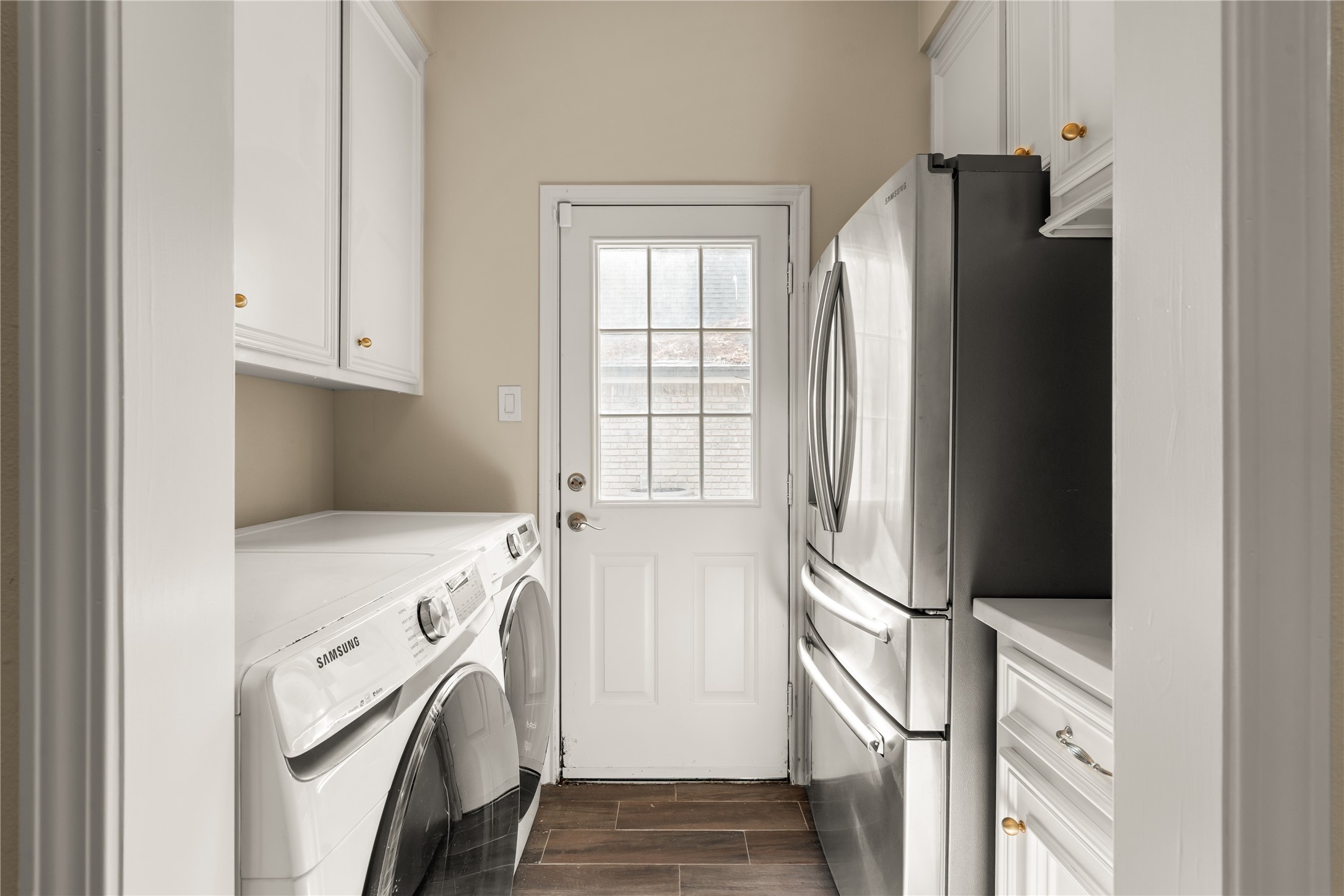 A highly functional utility room provides excellent cabinetry and storage, space for full-size laundry appliances and an additional refrigerator, plus convenient exterior access.