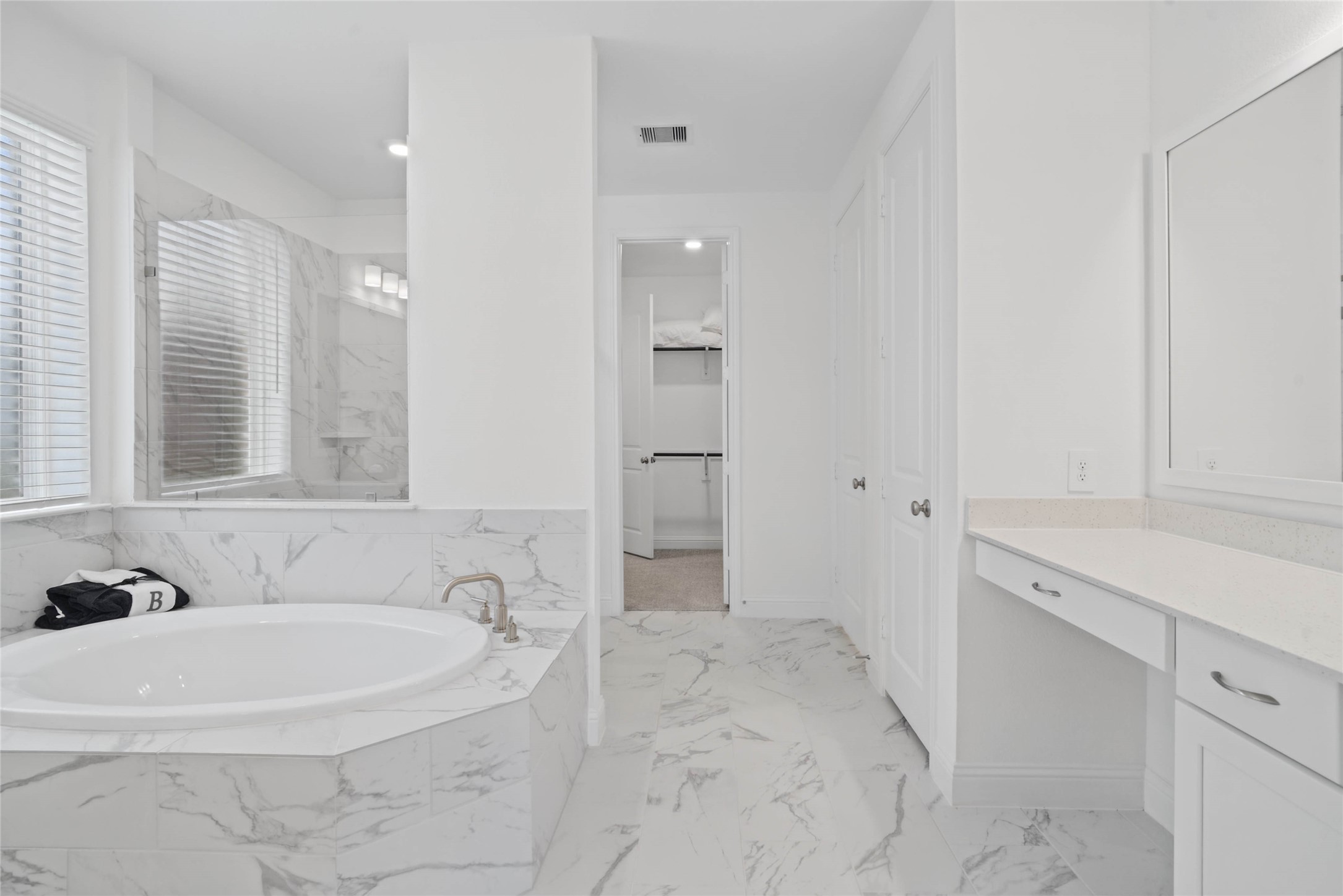 Modern primary bath features dual vanities with sleek cabinetry, quartz countertop, and crisp brushed nickel fixtures for a truly contemporary feel.