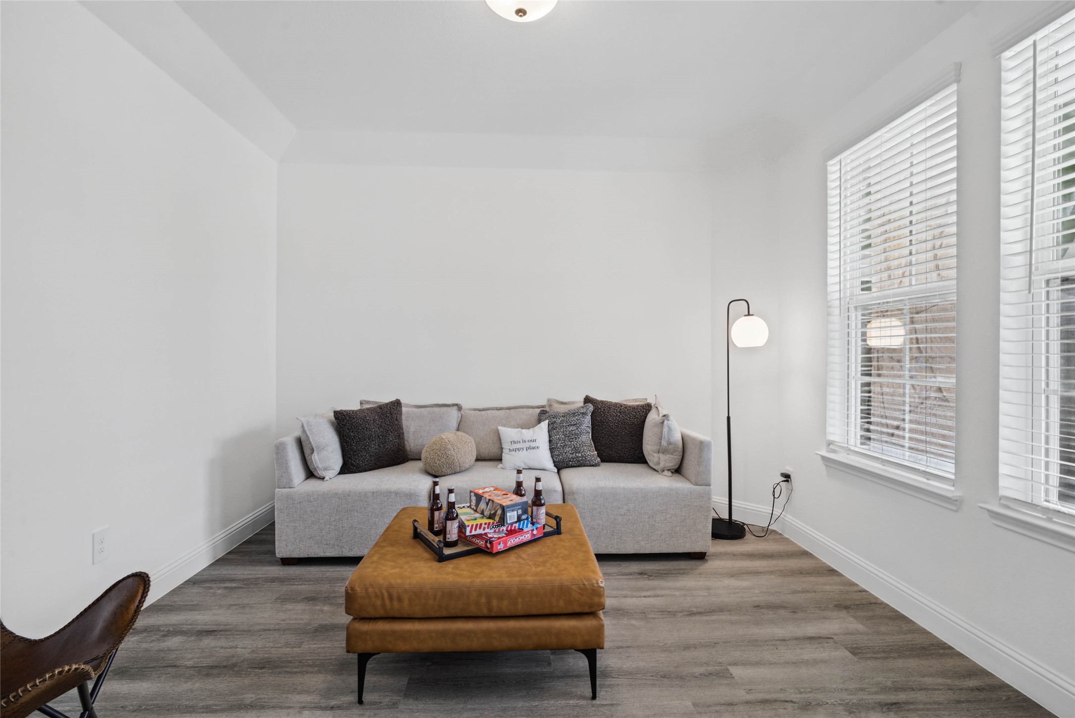 This handsome study  features luxury vinyl plank flooring, large windows with fitted blinds, high ceilings, lighting, and custom paint!