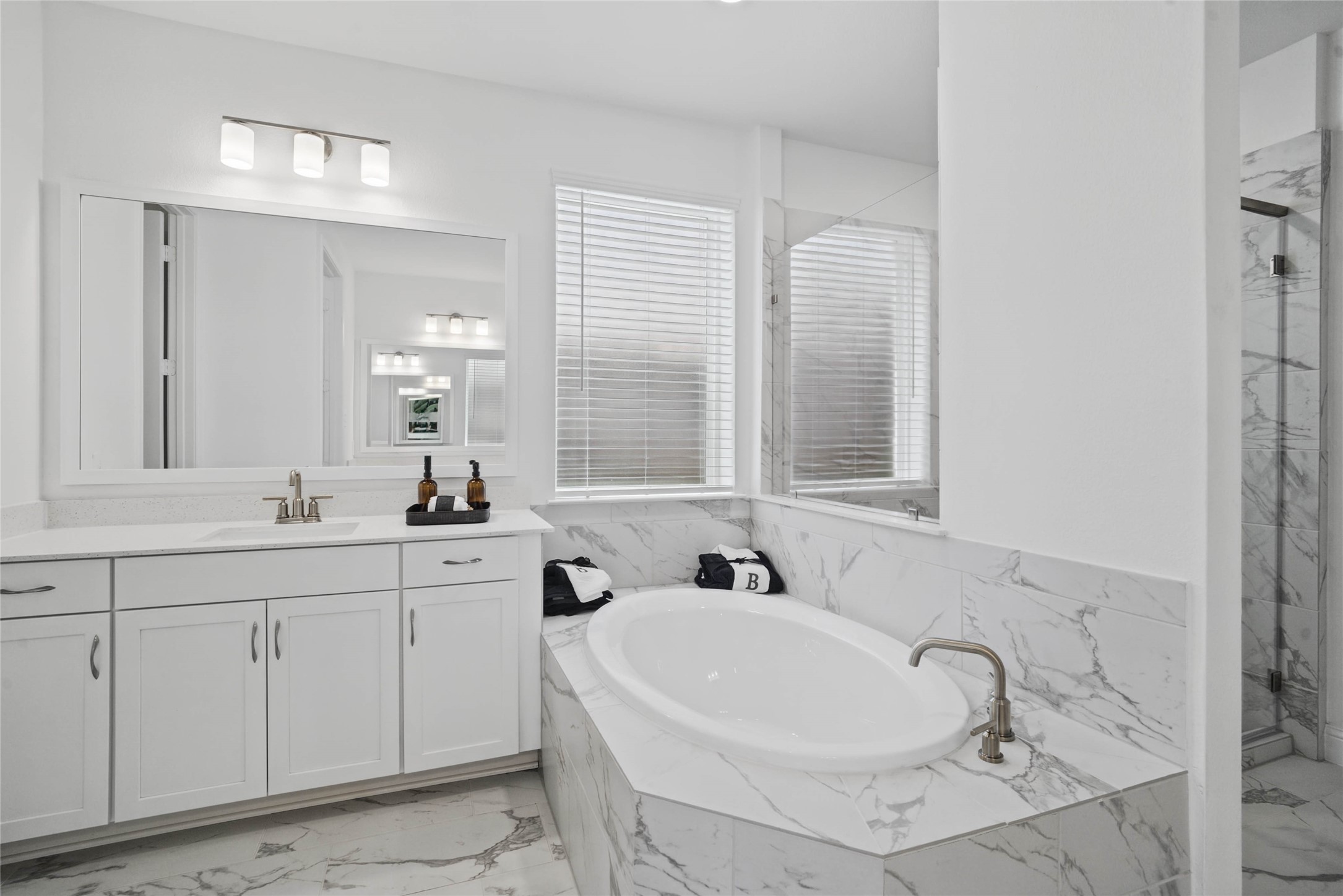 The centerpiece of this contemporary primary bath is the deep, freestanding bathtub, offering an ideal spot for relaxation with a unique view into the walk-in shower.