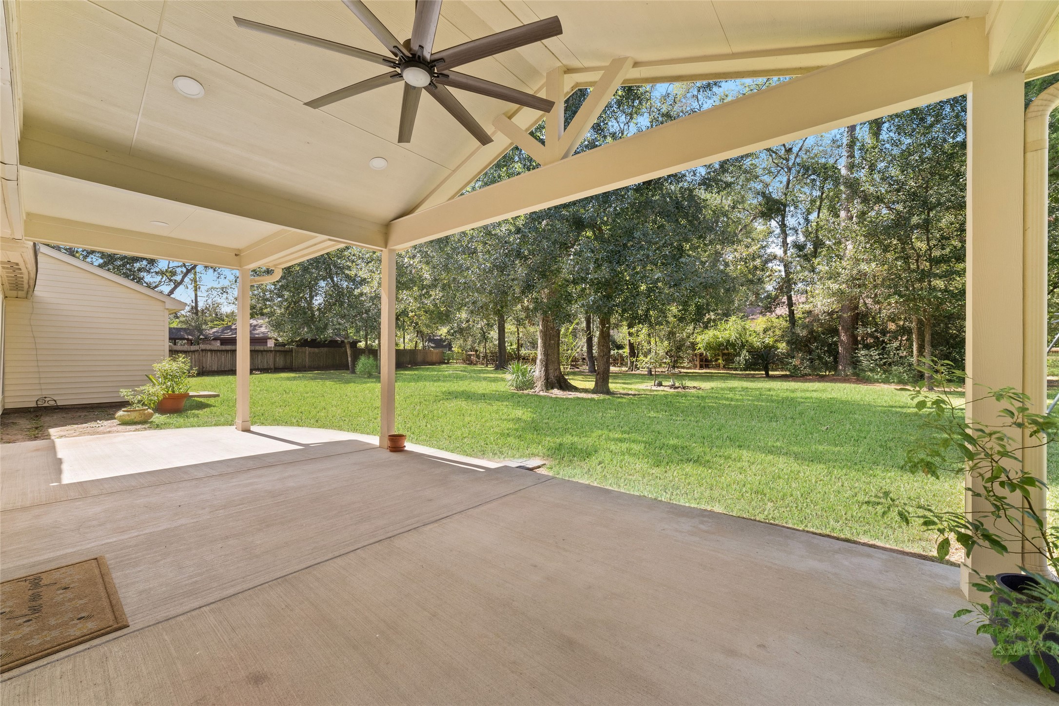 Morning coffee surrounded by nature, an evening cocktail while the kids play in the backyard, or a relaxed dinner al fresco with family and friendsthis expansive covered patio is made for enjoying life's simple pleasures. With a vaulted ceiling, exposed beams, and ceiling fan, it's a beautiful extension of the home's living space, overlooking the sprawling lawn and mature shade trees